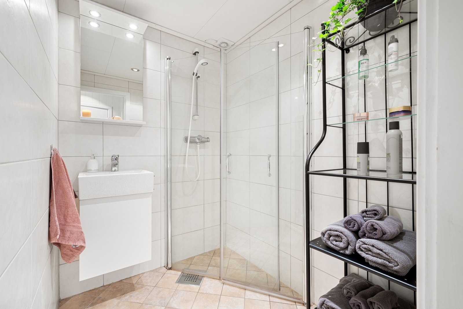 Lekkert flislagt bad fra 2010 med vegghengt innredning og romslig dusjnisje. Galleribilde