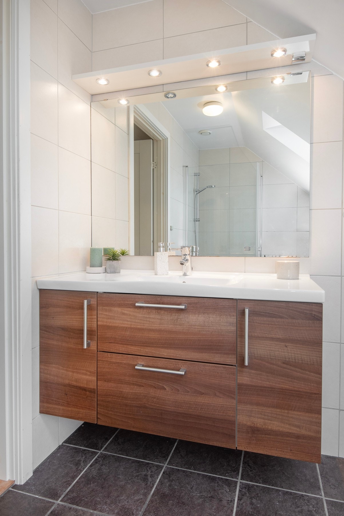 Rommet har innredning med nedfelt servant, veggmontert toalett og dusjvegger/hjørne. Galleribilde