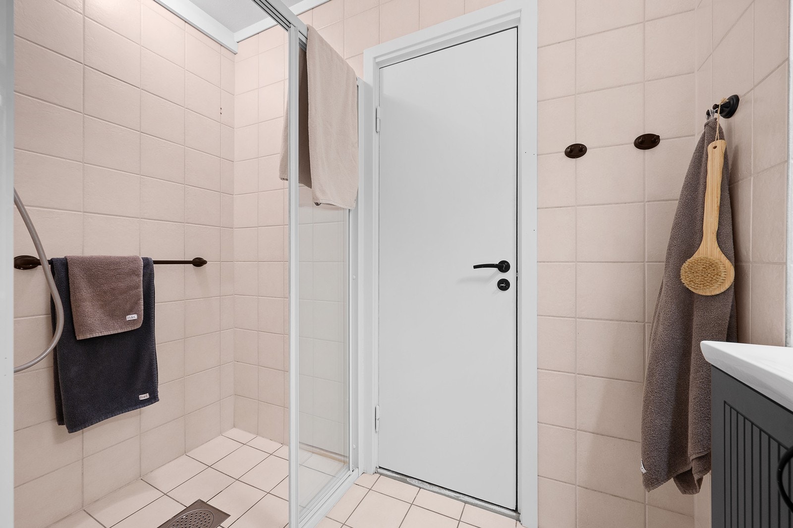 Flislagt bad med varme i gulv. Utstyrt med dusjhjørne, innfellbare dusjdører, naturlig avtrekk, opplegg for smal vaskemaskin, gulvstående wc og rørfordelingsskap Galleribilde