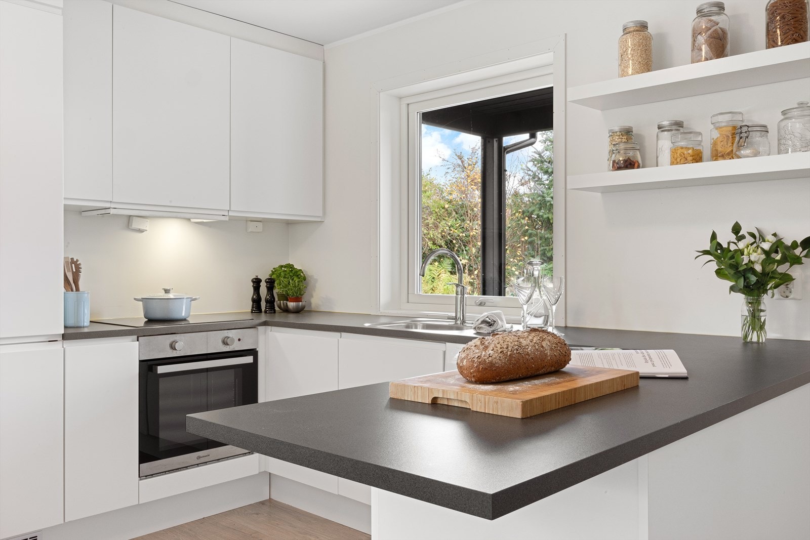 Gulvet i stue/kjøkkenområdet er belagt med slitesterk laminat med varmekabler, og vegger og tak er kledd med malte plater som gir en pen, tidløs finish. Galleribilde