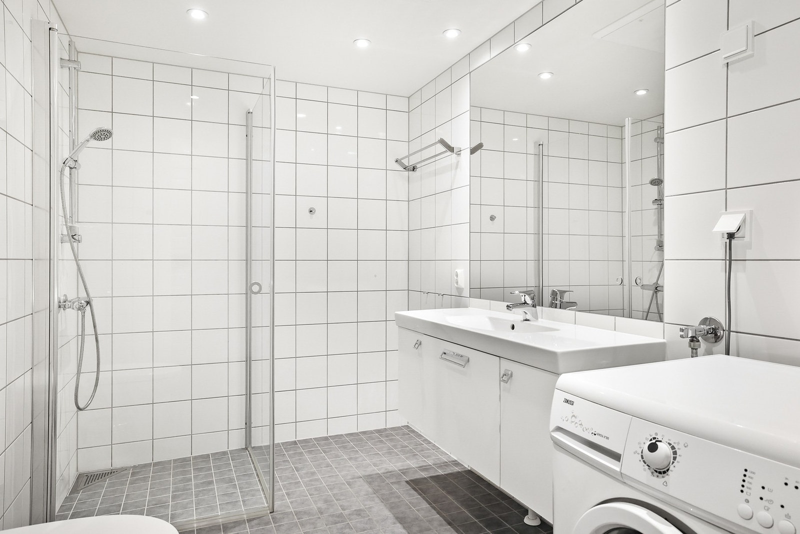 Badet er også utstyrt med dusj, vegghengt toalett, opplegg til vaskemaskin. Det er også gulvvarme. Galleribilde