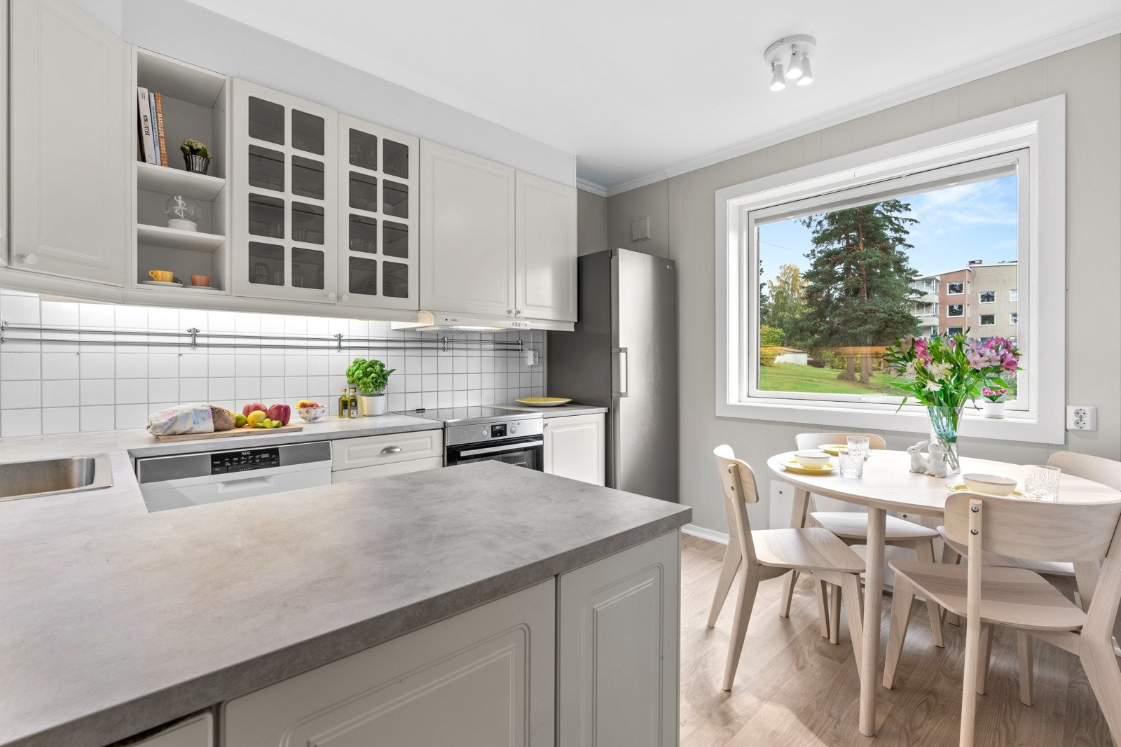 Vi tar turen videre inn på kjøkkenet. Kjøkkeninnredningen er holdt i lyst og består av profilerte fronter og benkeplate av laminat. Galleribilde