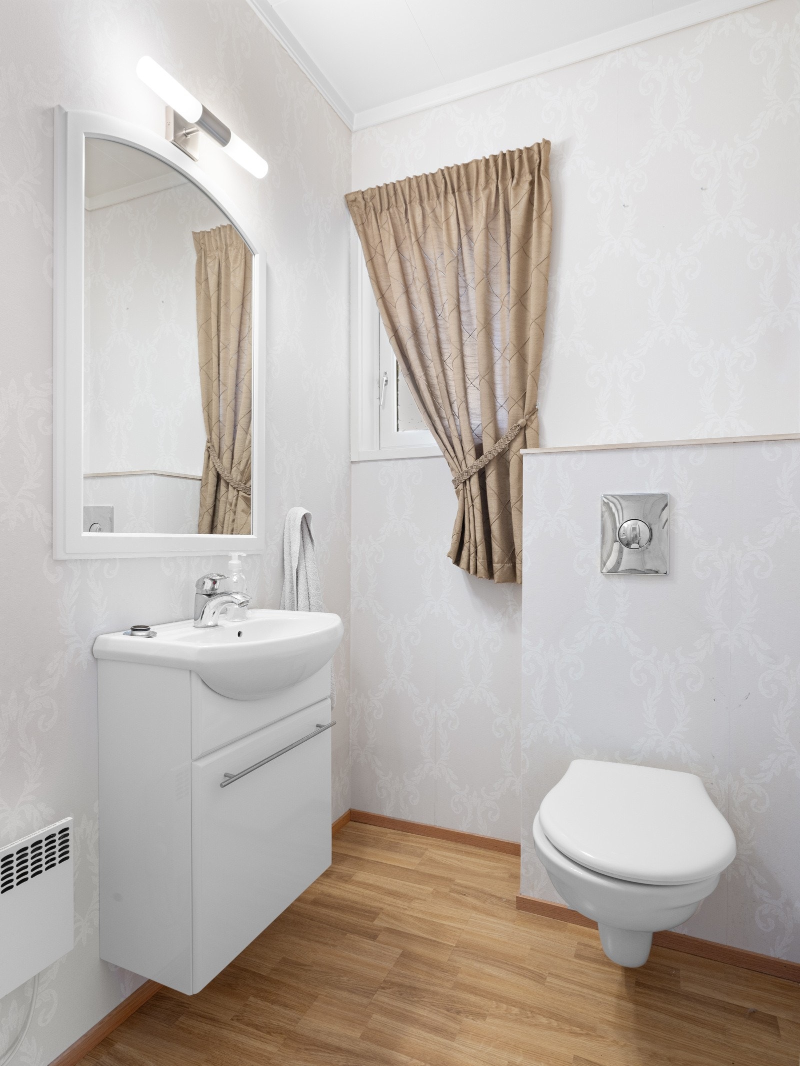 Pent toalettrom med vegghengt wc og dekortapet Galleribilde