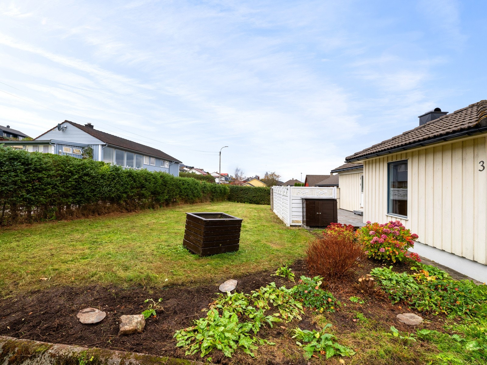 Hagen er pent beplantet med hekk, plen og bed Galleribilde