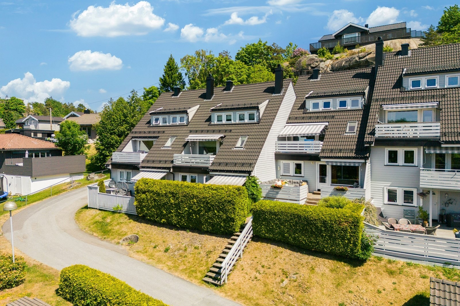 Pent opparbeidet tomt med asfalterte adkomstveier og parkeringsplasser. Beplantet med gressplen og
diverse prydvekster. Galleribilde