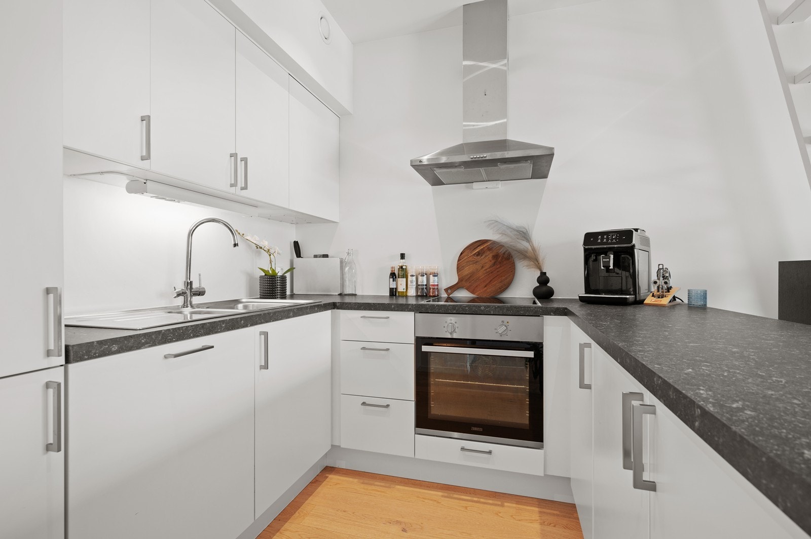 Lys kjøkkeninnredning med integrerte hvitevarer. Her har du plass til det du skulle trenge av kjøkkenutstyr og servise. Galleribilde