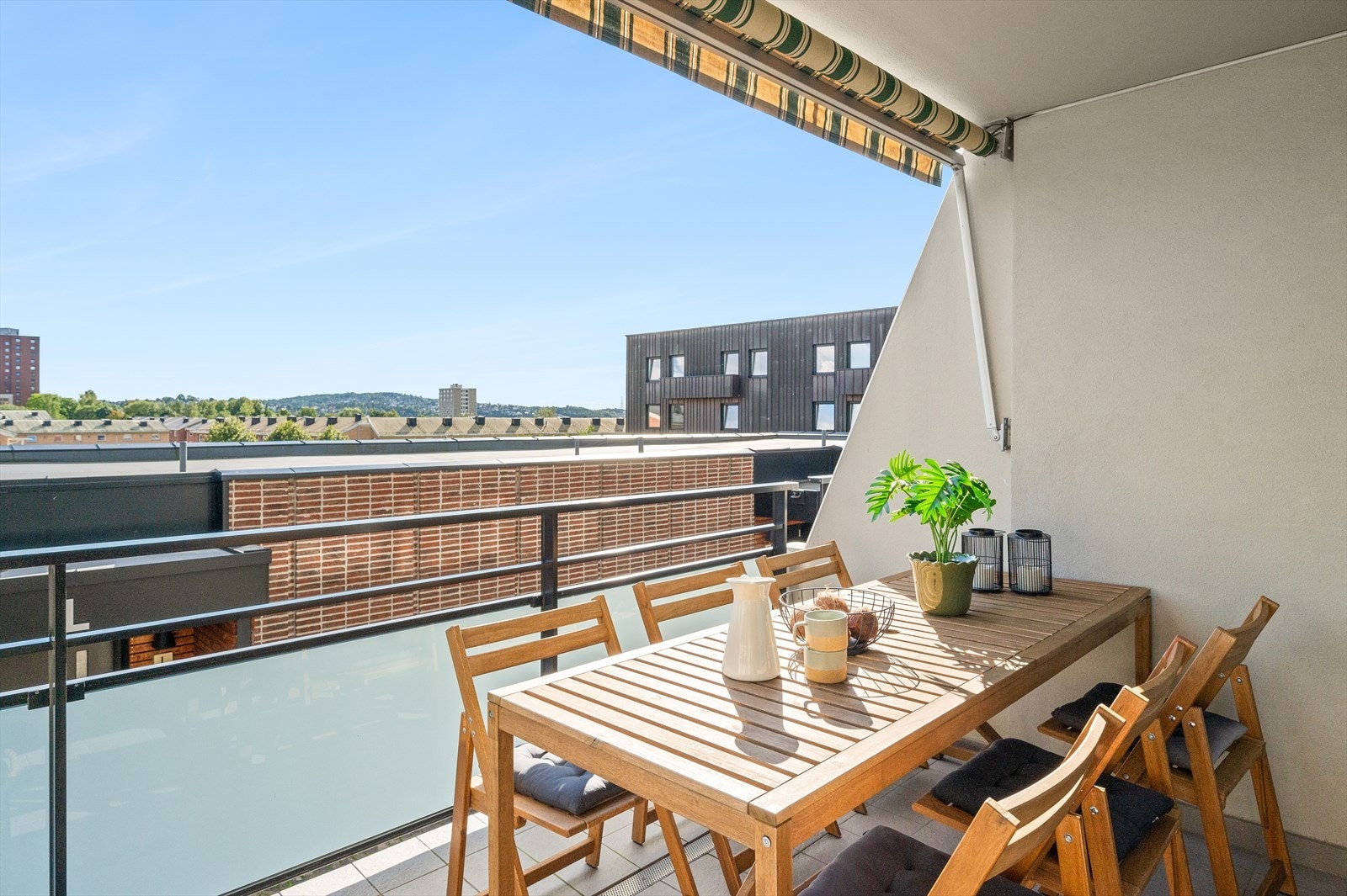 Med fliser på balkongdekke og en elektrisk markise, er denne plassen ideell for avslapning. Galleribilde