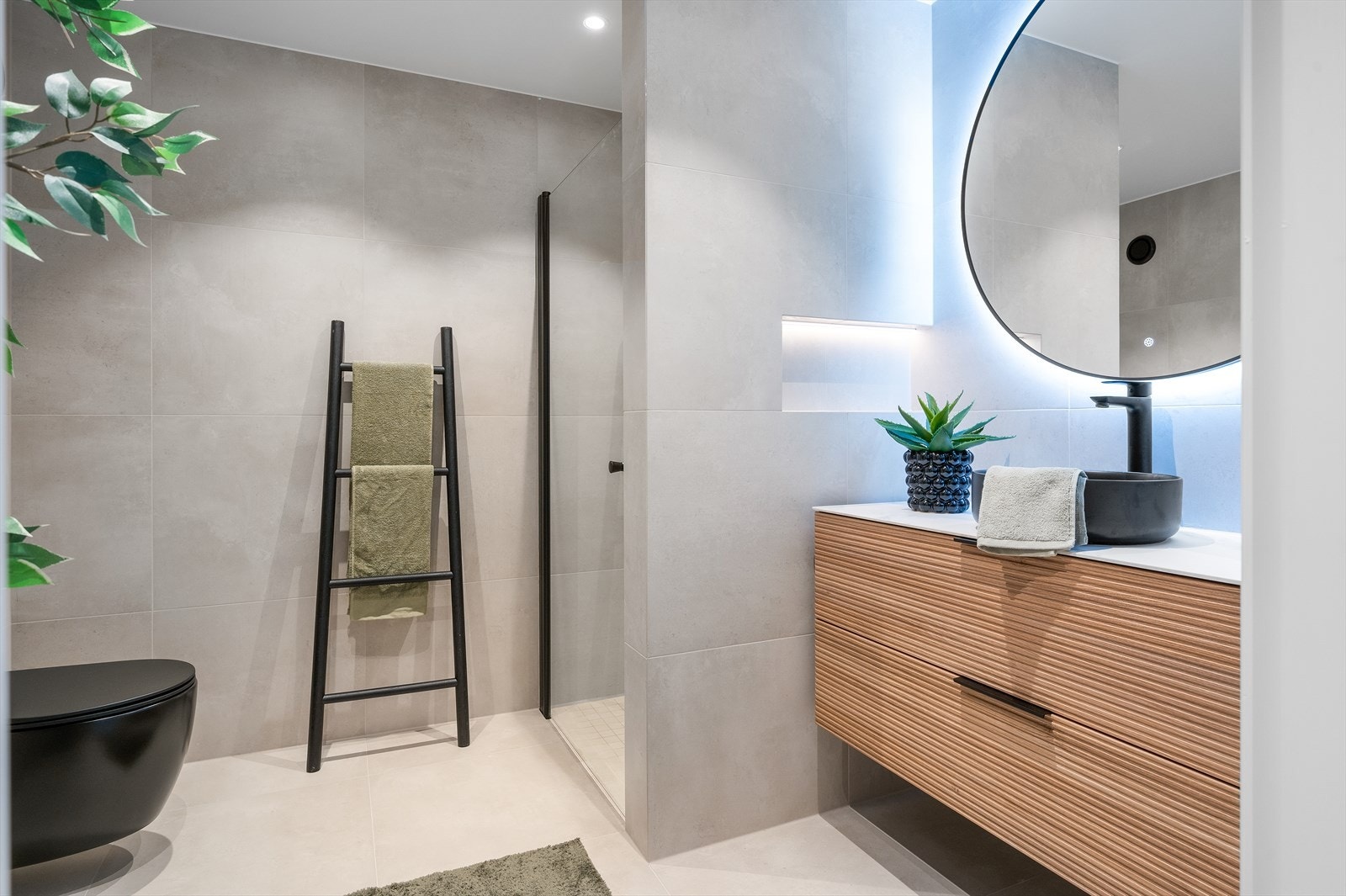 Rålekkert bad med delikate fliser, dusjnisje og flott innredning med sorte detaljer. Speil med belysning. Galleribilde