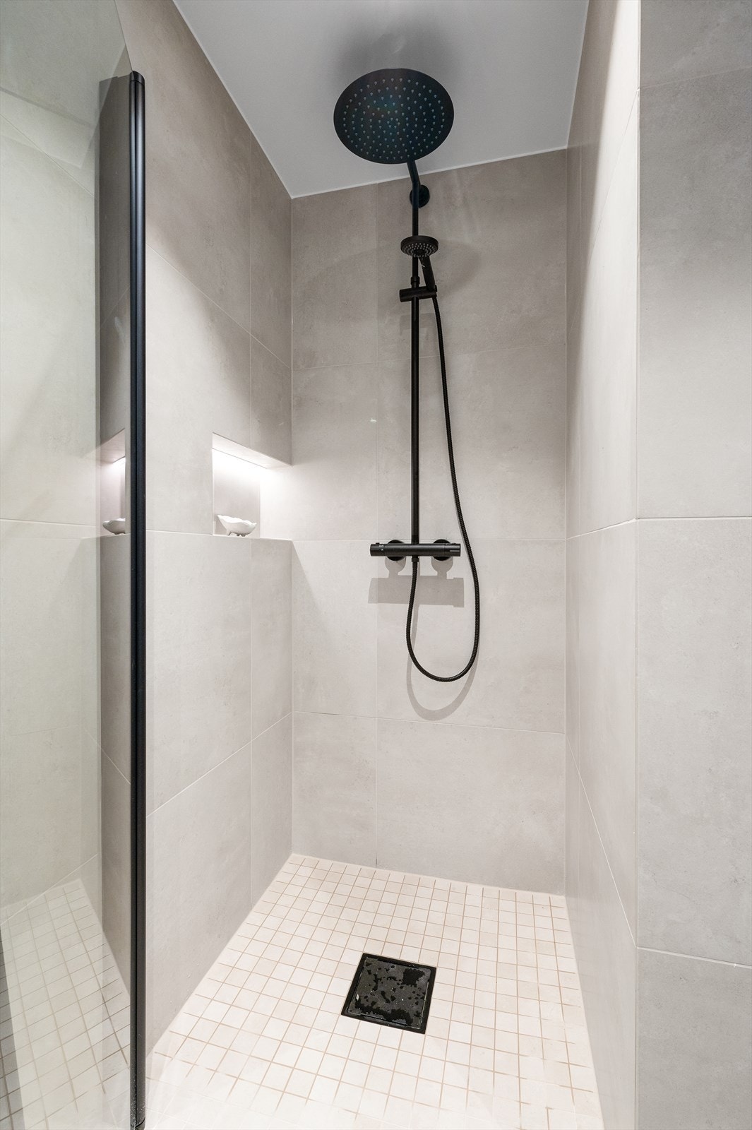 Badet er elegant utformet med 60x60 fliser og mosaikkfliser i dusjsonen. Galleribilde