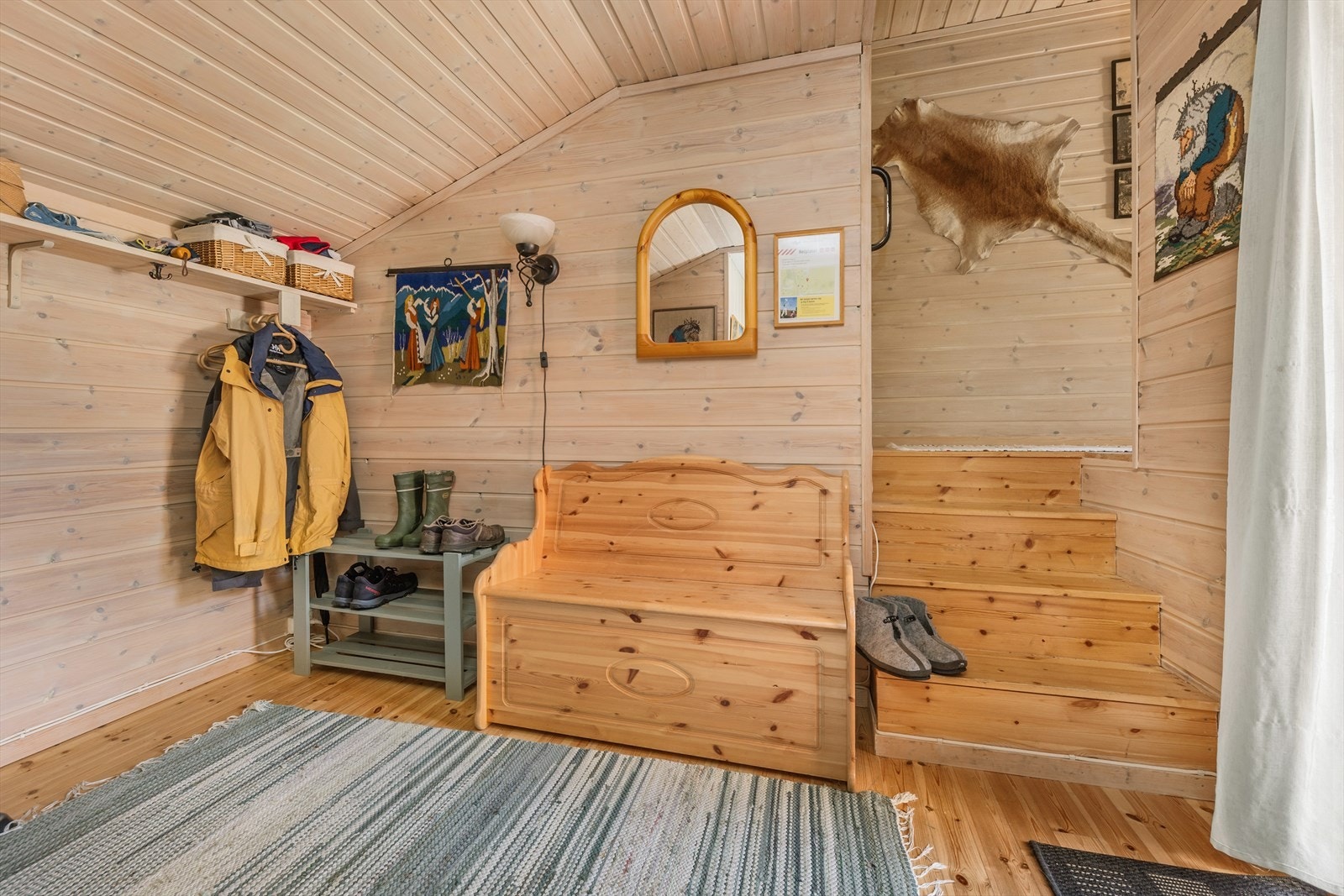 Koselig inngangsparti med trepanel og praktisk oppbevaring. Perfekt for friluftsentusiaster med plass til klær og sko. Galleribilde