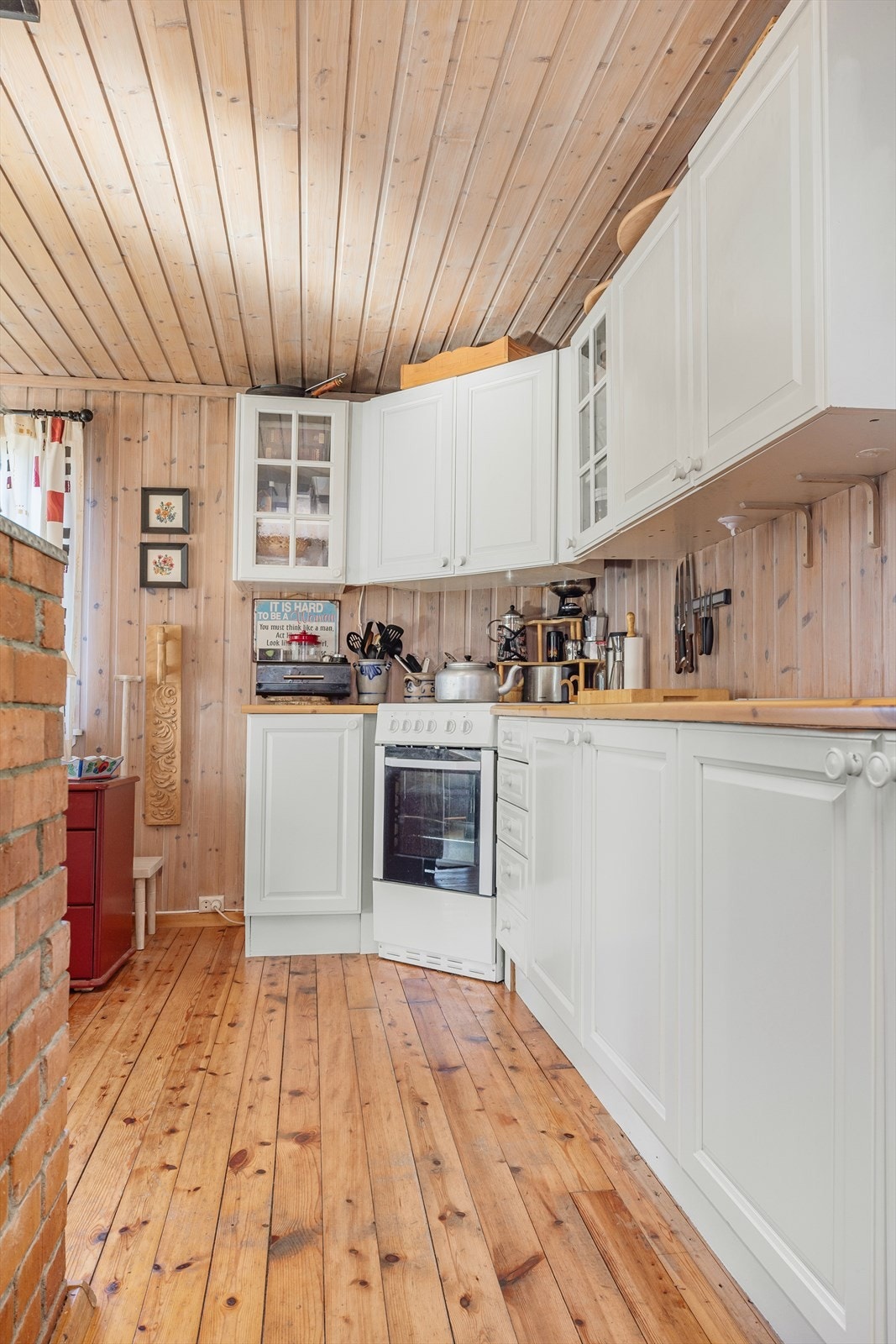 Koselig kjøkken med tregulv og lyse flater, praktisk innredet med god skapplass og naturlig lysinnslipp. Galleribilde