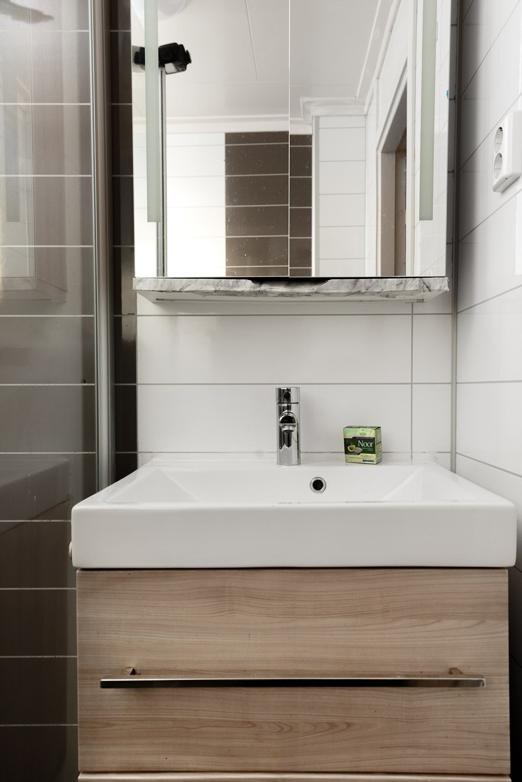 Baderomsinnredning med vask i porselen og speil over. Galleribilde