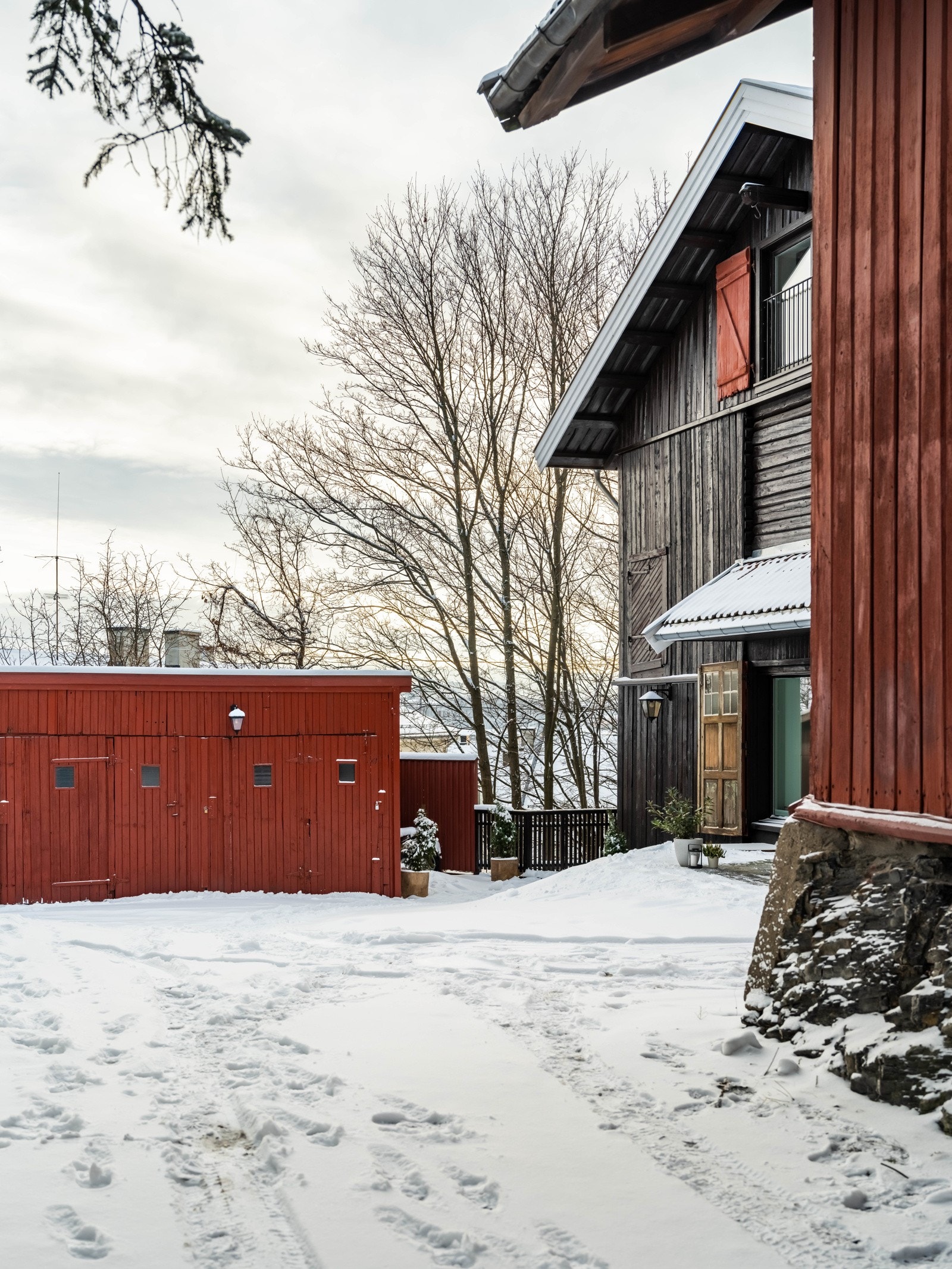 Inngangspartiet er mellom vognstallen og låven, midt i bildet. I vognstallen er også garasjeplassen og boden. Galleribilde