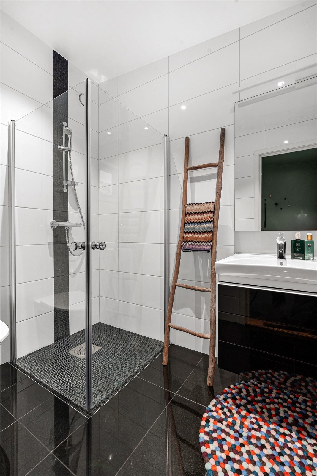 Flislagt bad med servant i møbel, dusj og vegghengt toalett. Galleribilde