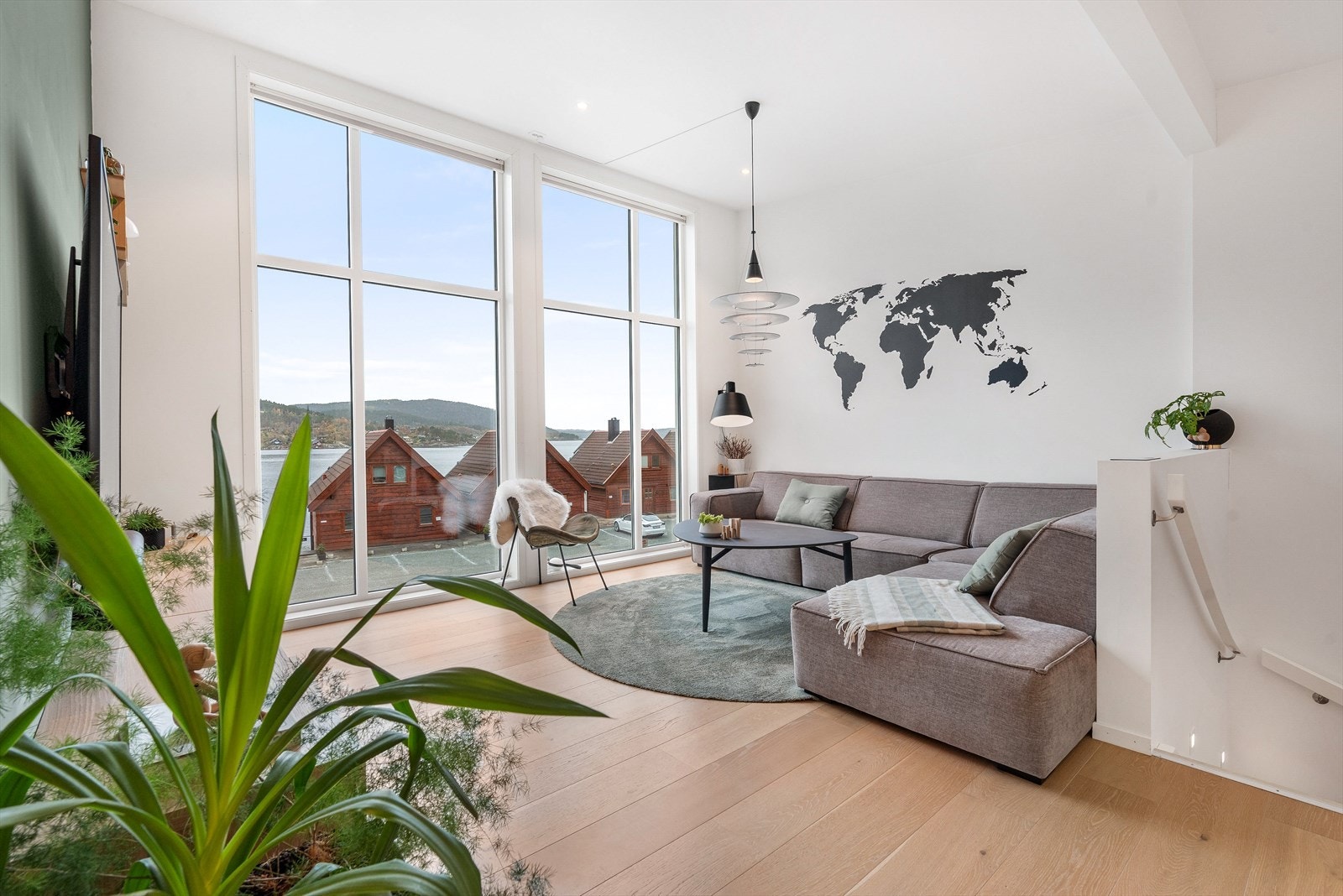 Åpen og lys stue med god takhøyde og store vindusflater, parkett på gulv og gips i vegg/tak. Galleribilde