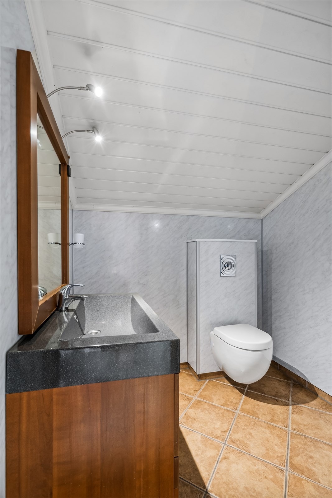 Rommet har innredning med nedfelt servant, veggmontert toalett og dusjkabinett. Galleribilde