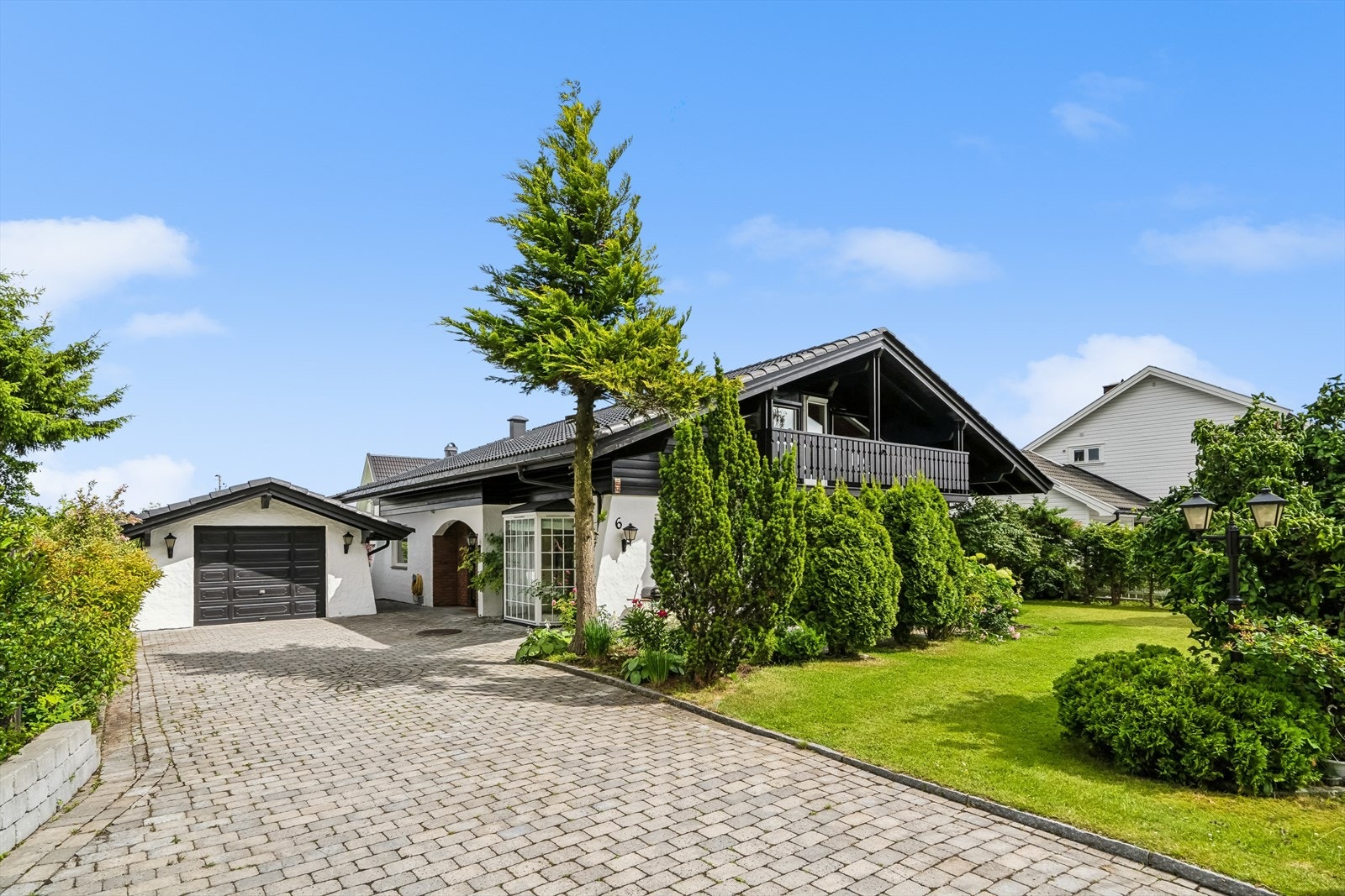 Boligen gir et godt førsteinntrykk med lettstelte brostein i innkjørselen og flott beplantning. Galleribilde