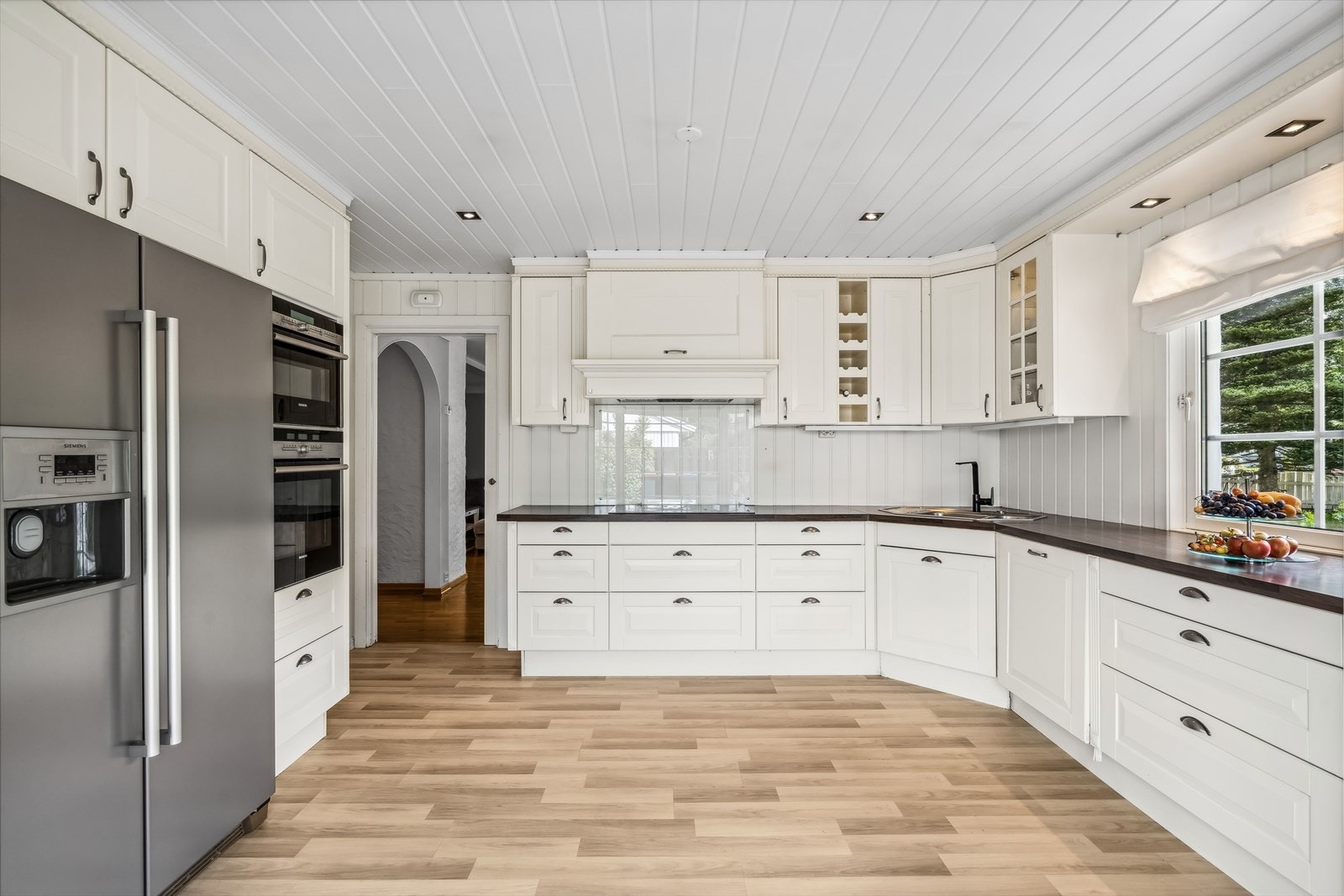 Kjøkkenet er fra Sigdal med integrerte hvitevarer og fin, klassisk stil. Kjøkkenet har innredning med profilerte fronter. Benkeplaten er av laminat. Det er avsatt plass til amerikansk kjøleskap i nisje. Galleribilde