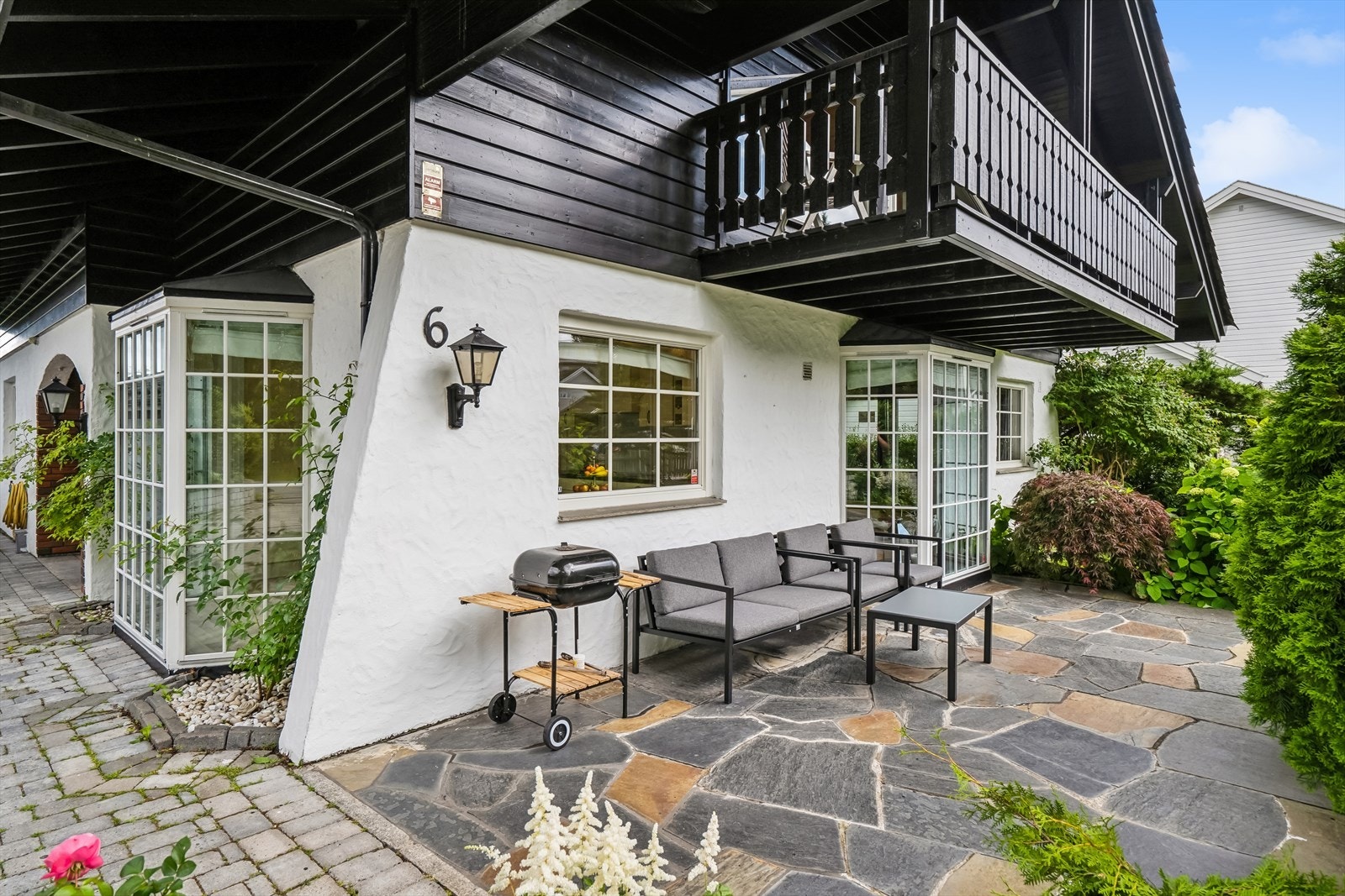 Boligen har flere fine uteplasser , bøant annet denne steinlagte terrassen ved inngangen. Galleribilde