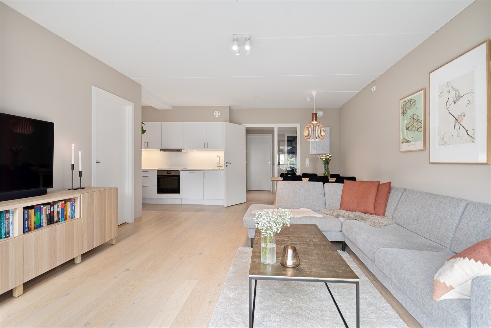 Åpen løsning mellom stue og kjøkken bidrar til et sosialt og hyggelig oppholdsrom Galleribilde