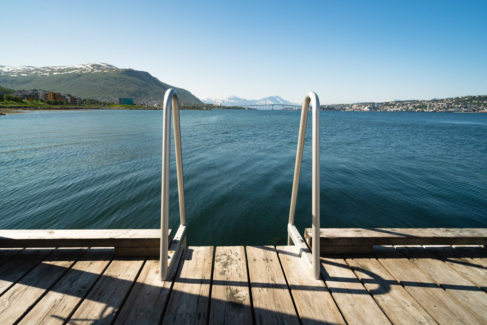 Solrike og pene felles uteområder med plen, sittebenker og flott bryggepromenade.