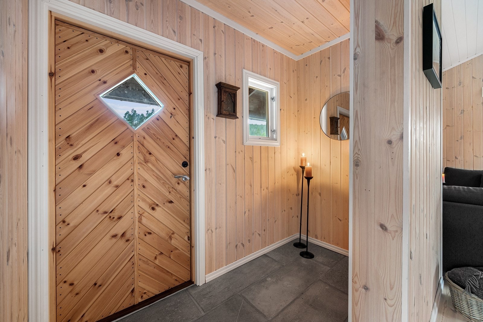 Entréen fremstår lys og trivelig med skiferfliser på gulvet og lysbeiset panel på veggene. Galleribilde