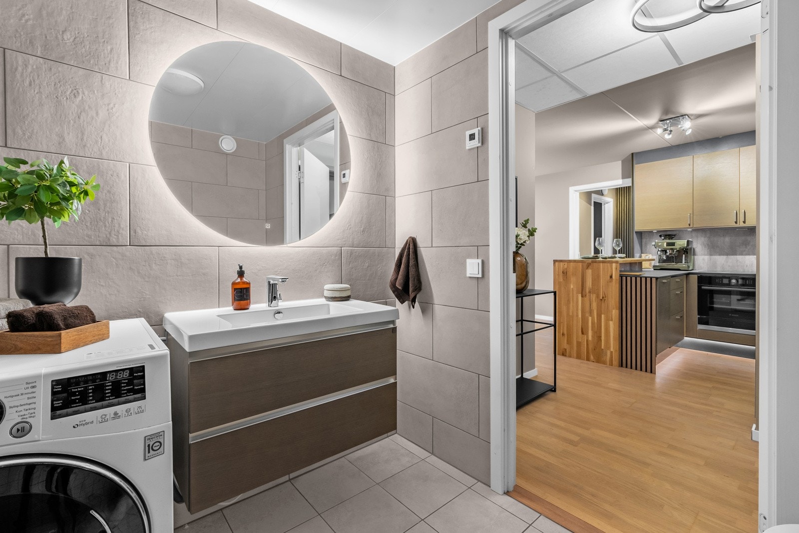 Baderommet inneholder servant med underskap, speil med belysning, vegghengt toalett og dusjhjørne med hånddusj og regnfallsdusj. Galleribilde