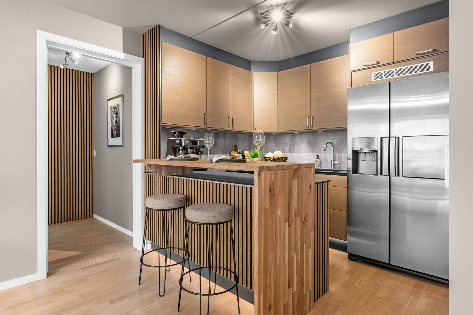 Kjøkkenet er også delvis dekket med spilevegg, noe som sørger for et lekkert uttrykk. I tillegg er det en praktisk løsning med barbord i eik. Galleribilde