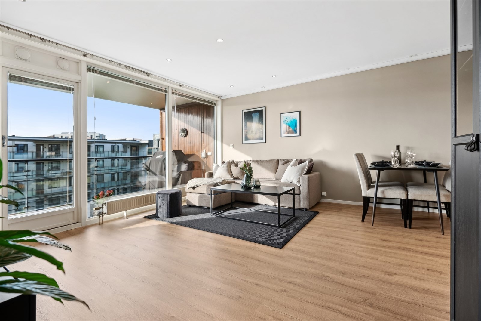 Åpen stue- og kjøkkenløsning med plass til spisebord i tilknytning til kjøkken Galleribilde