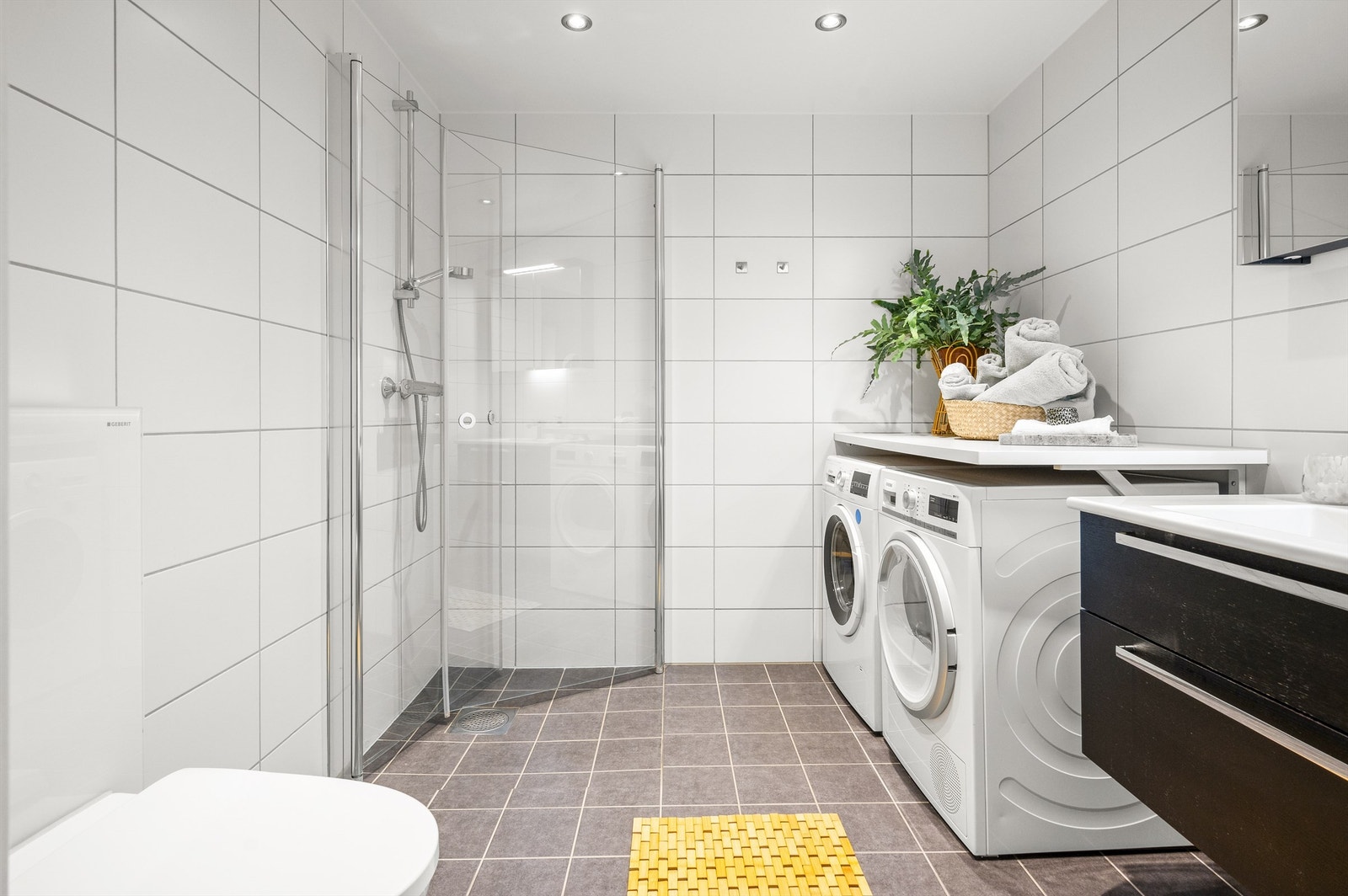 Innbydende og meget romslig bad med fliser, varme i gulv og downlights i himling Galleribilde