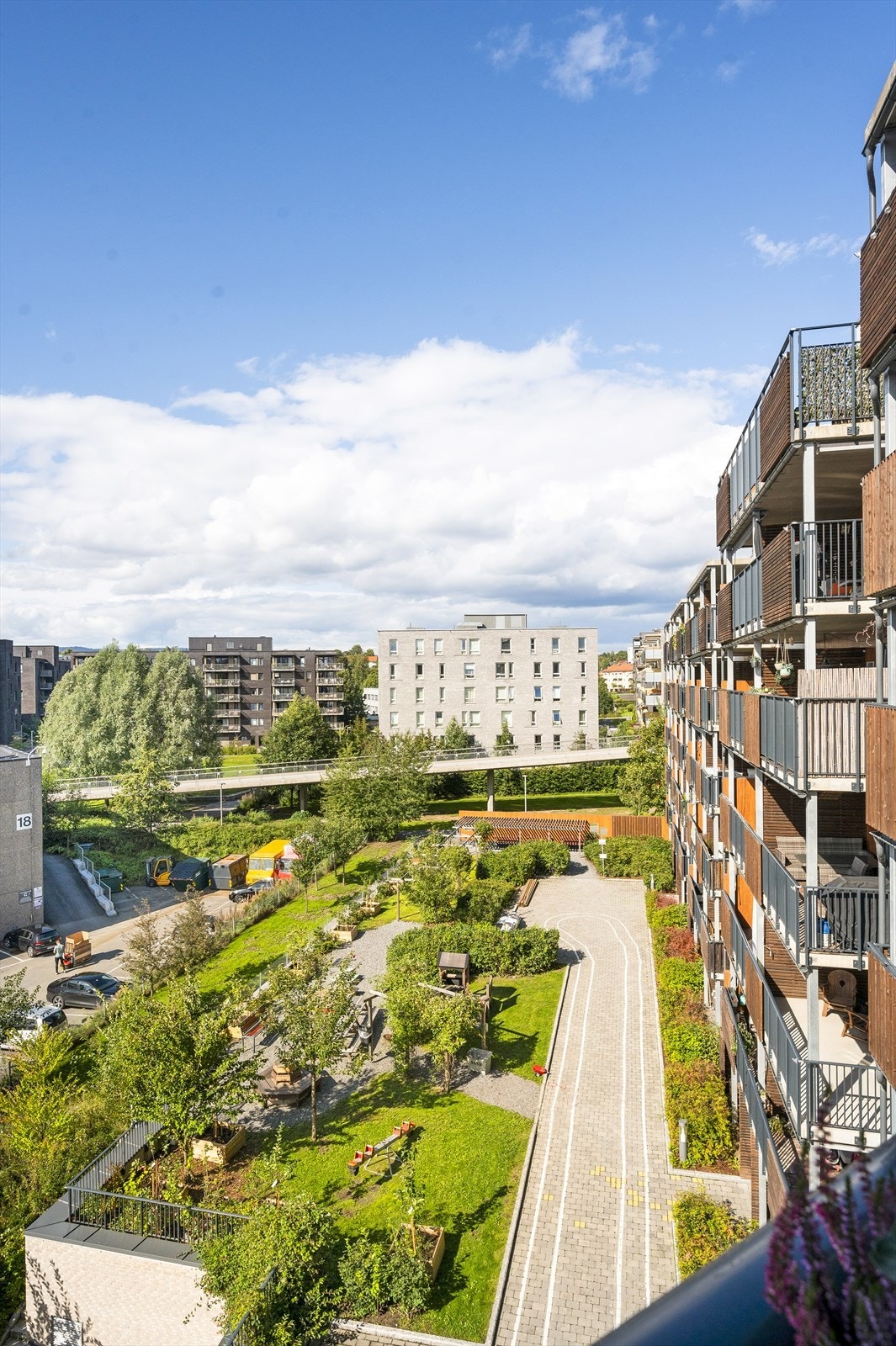 Fra balkongen er det blant annet utsyn mot sameiets fellesområder, i et hyggelig gårdsrom med pent opparbeidet gangsti, frukttrær og bærbusker Galleribilde