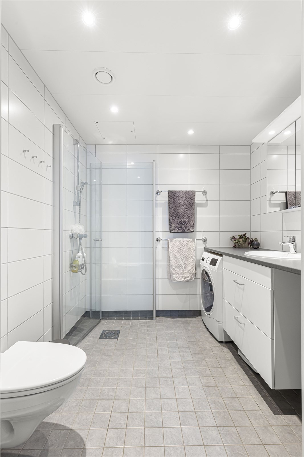 Pent flislagt bad med elektrisk gulvvarme. Det er opplegg til vaskemaskin og tørketrommel. Galleribilde