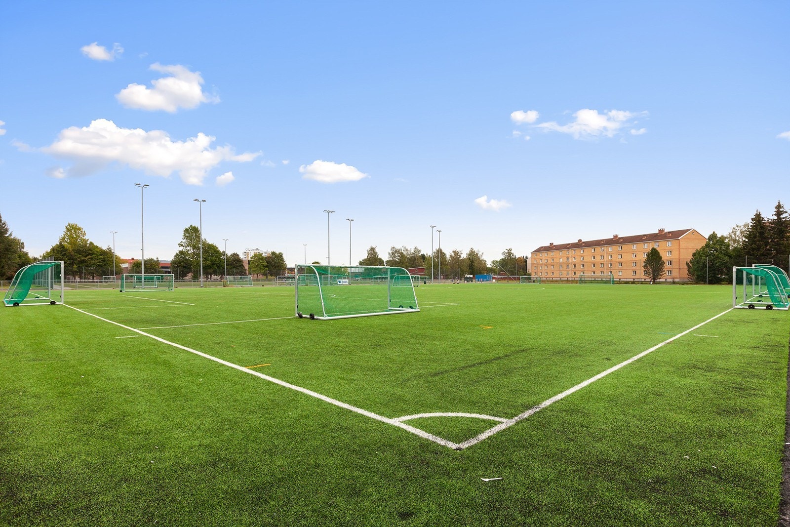 Fotballbane like ved boligblokken. Nærhet til treningssenter, marka og grøntareal. (sommerbilde) Galleribilde