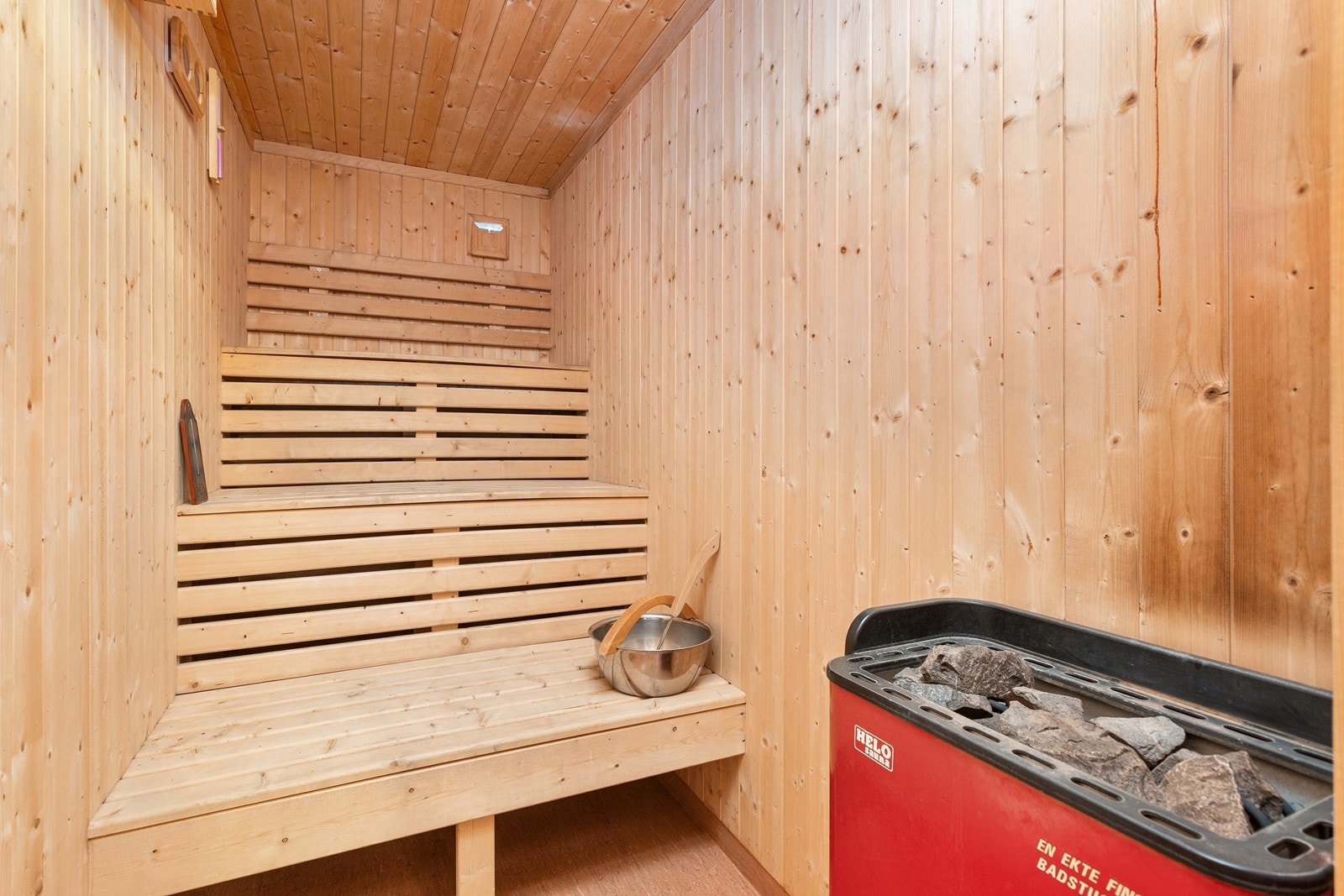 Fra badet er det også tilgang til badstue innredet med sittebenker i tre og en badstuovn av typen Helo Sauna. Galleribilde