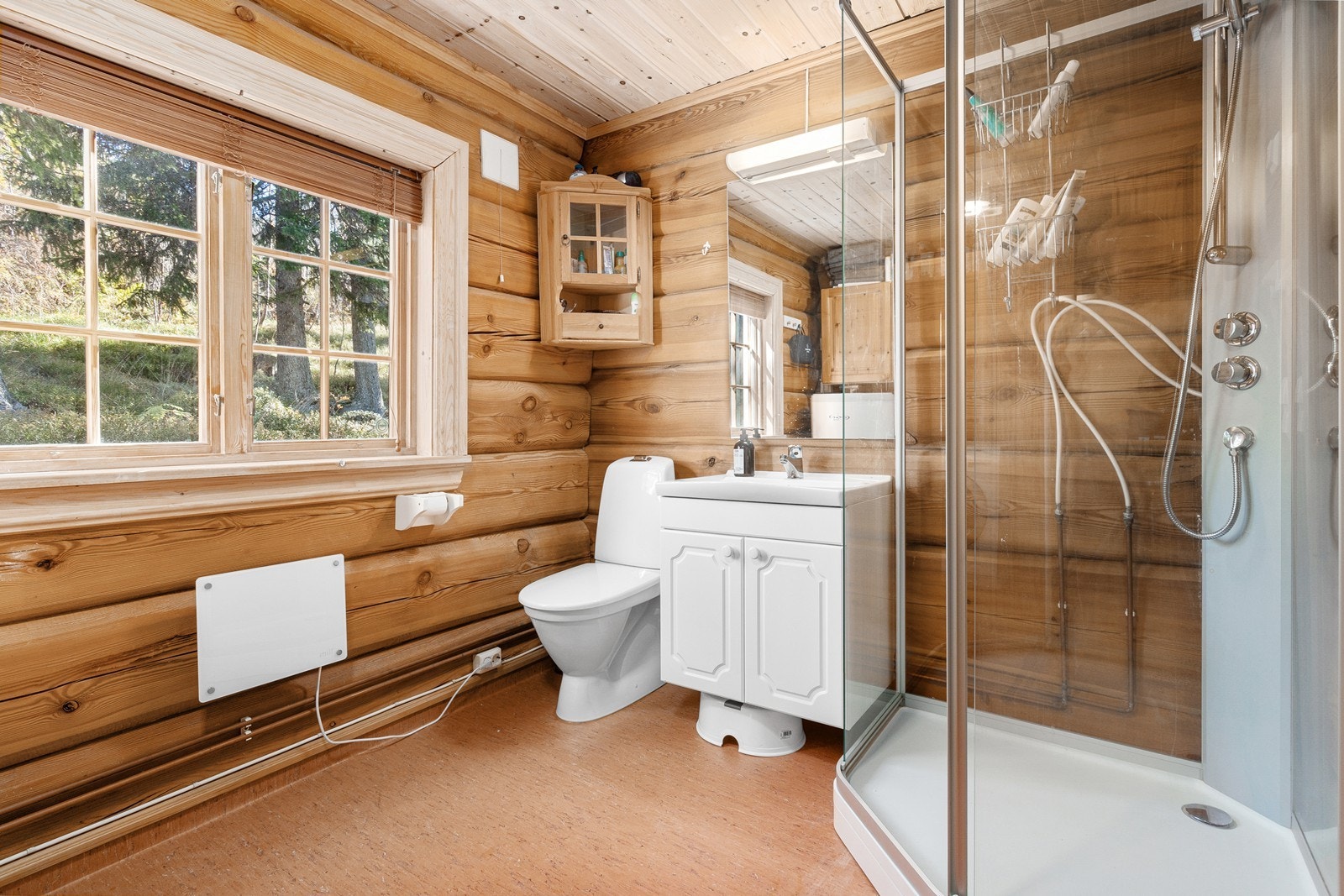 Badet er romslig og er utstyrt med innredning med to nedfelte servanter, toalett, dusjkabinett og opplegg for vaskemaskin. Galleribilde