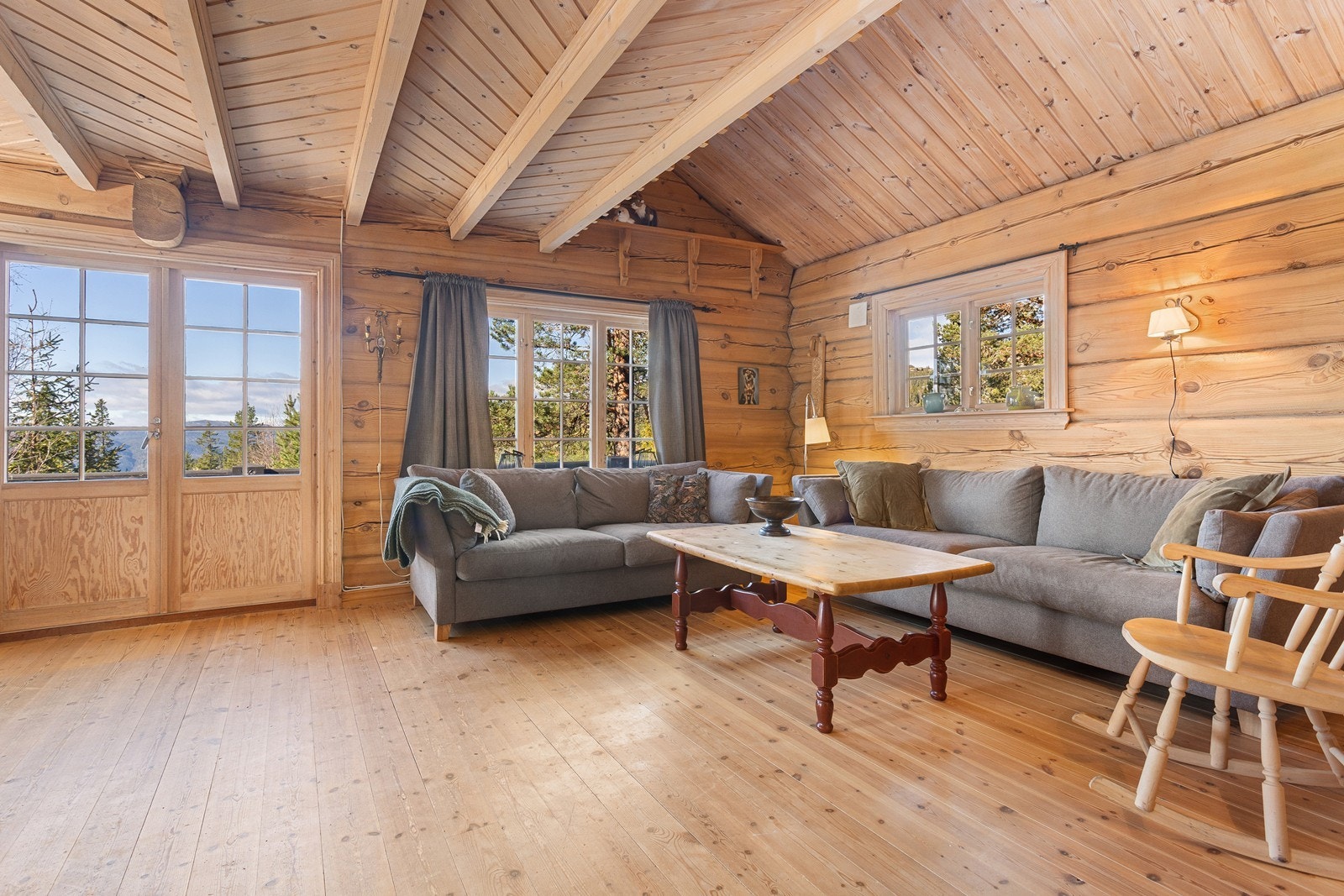 De flotte tømmerveggene gir en hyggelig atmosfære til rommet og de store vindusflatene slipper inn godt med naturlig dagslys. Galleribilde