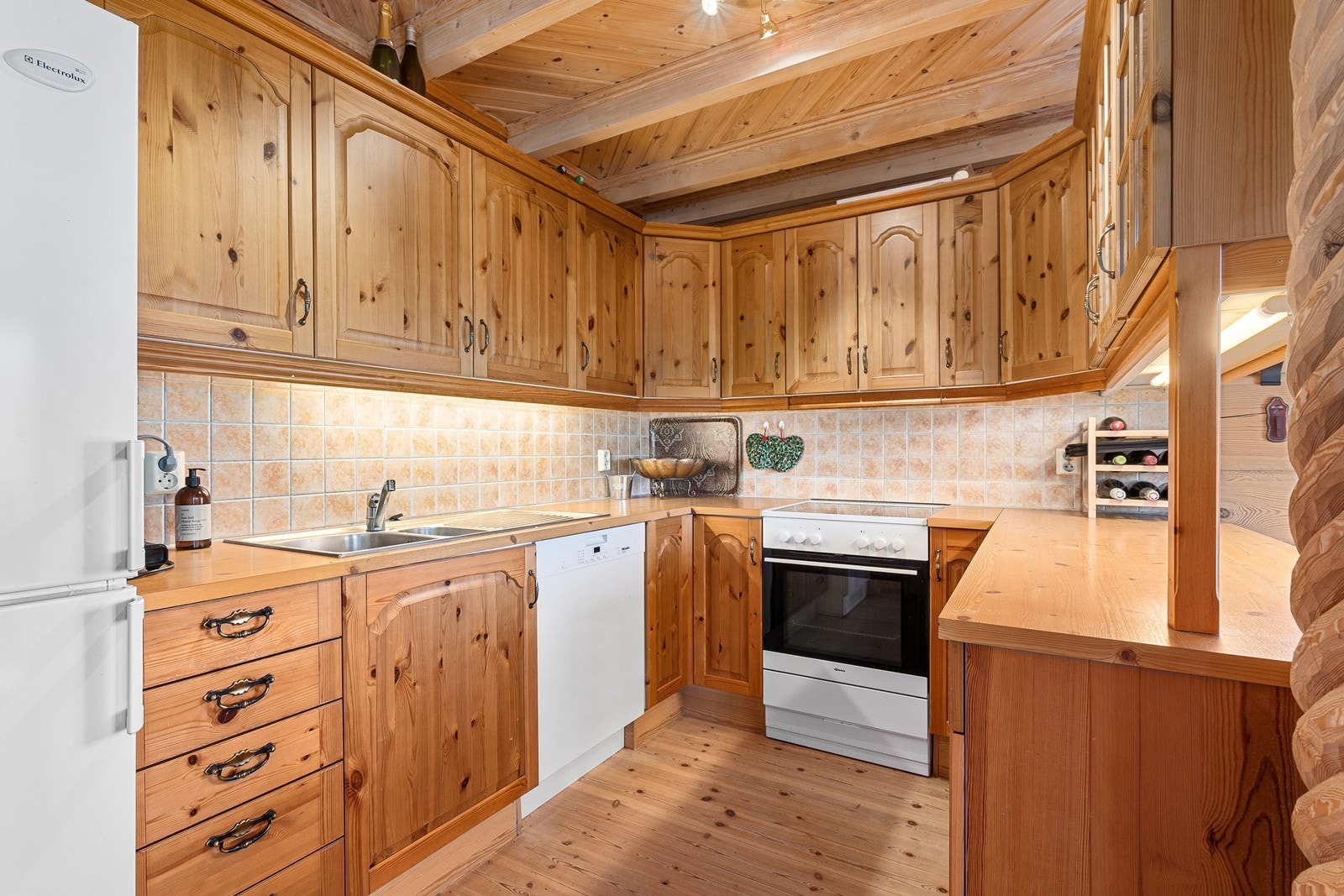 Kjøkkenet har innredning med profilerte fronter, benkeplate i laminat og avsatt plass til hvitevarer som komfyr, oppvaskmaskin og kjøleskap. Galleribilde