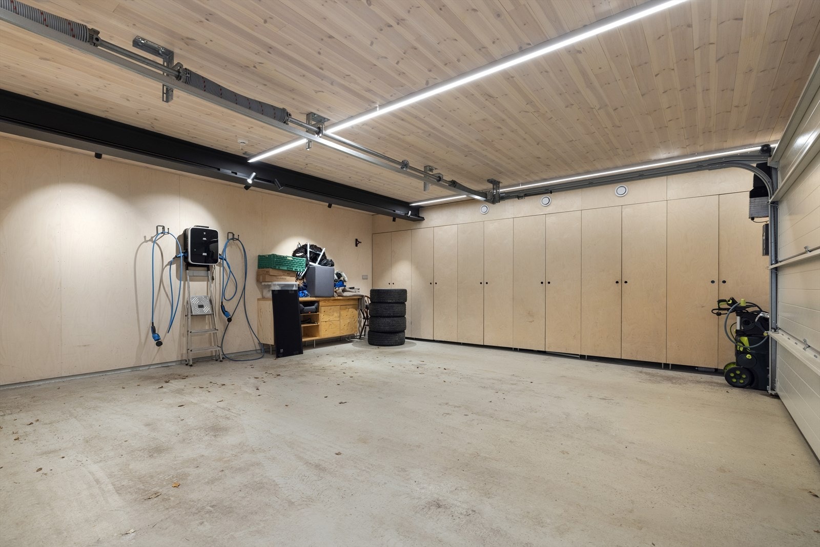 Dobbelgarasje med epoxygulv, ladestasjon for to biler, og lagring i plassbygde skap Galleribilde