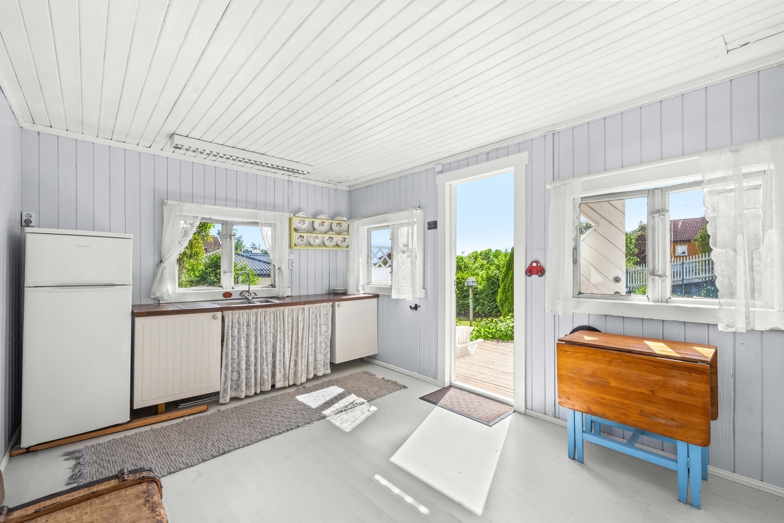 Uthuset har enkel kjøkkeninnredning og plass til kjøleskap Galleribilde