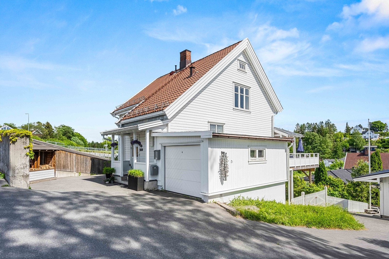 Det er en enkel garasje og biloppstillingsplass foran boligen Galleribilde