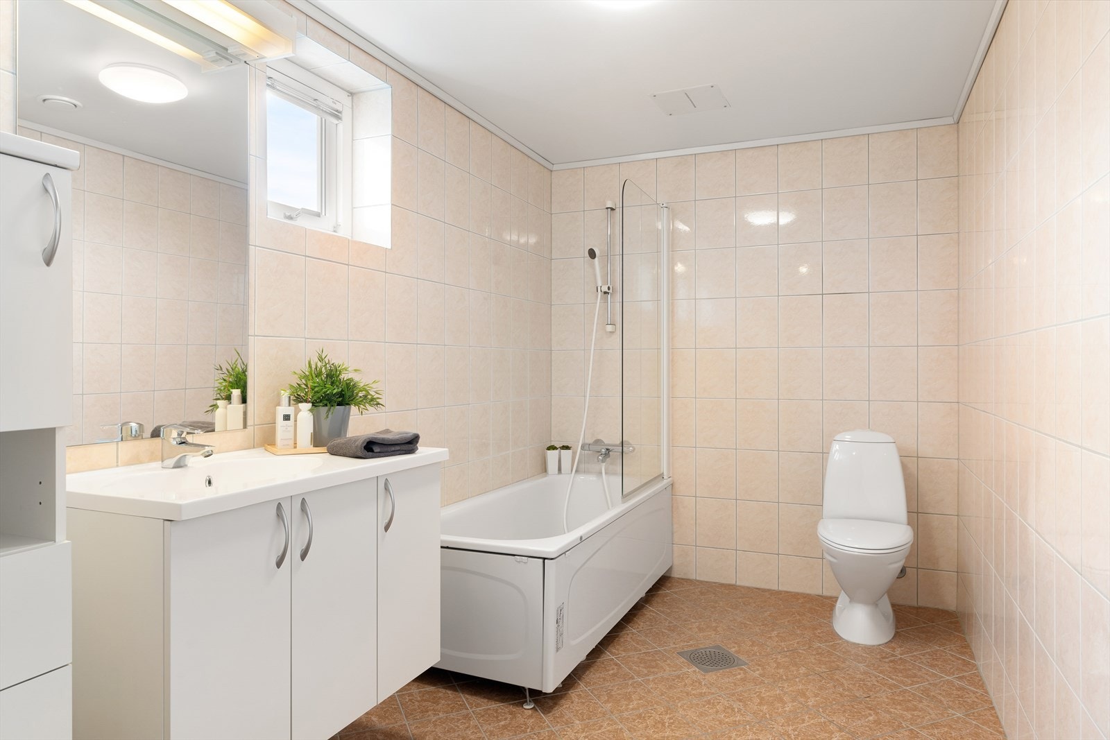 Badet er av god størrelse og har plass til badekar og bademøbler med godt med lagring Galleribilde