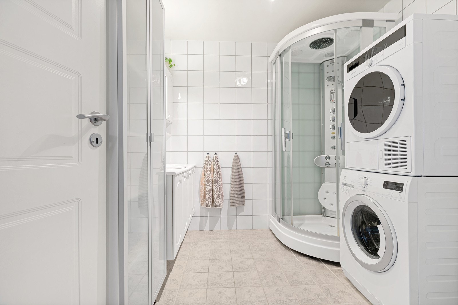 Badet har dusjkabinett og opplegg for vaskemaskin Galleribilde