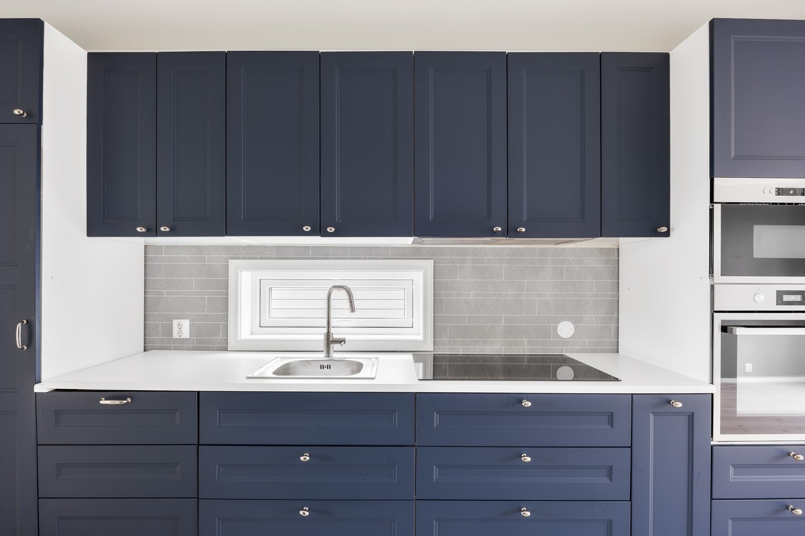 Kjøkkeninnredning med profilerte fronter og laminat benkeplate. Galleribilde