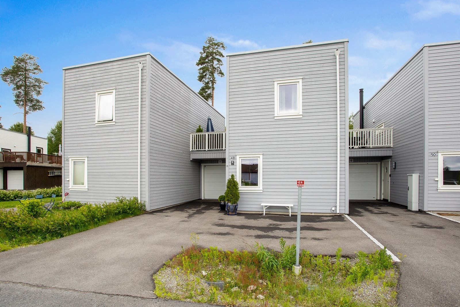 Fasade med inngangsparti, garasje og asfaltert innkjøring og parkering. Galleribilde