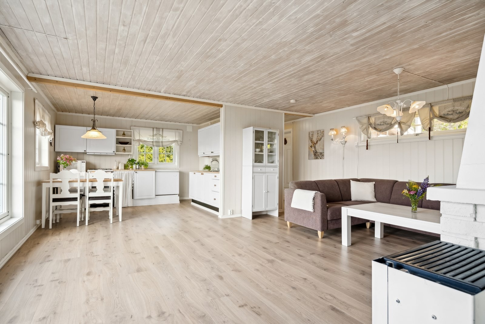 Stue og kjøkken i åpen løsning med store vinduer med naturskjønn utsikt. Allrommet oppleves åpent og luftig. Galleribilde