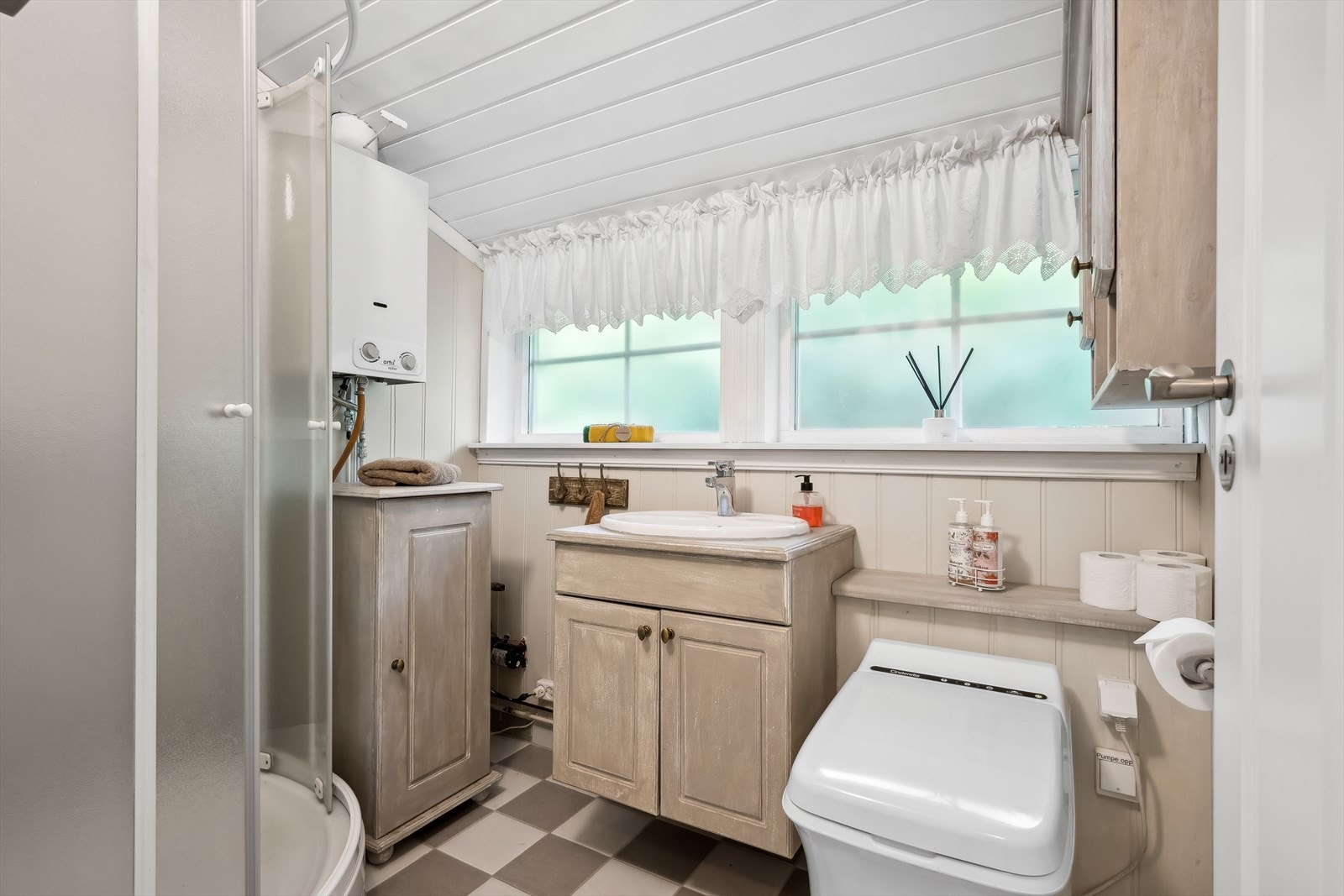 Badet er delvis fliset med varmekabler i gulv. Innredet med servantskap, Cinderella (gass) forbrenningstoalett og dusjkabinett. Galleribilde