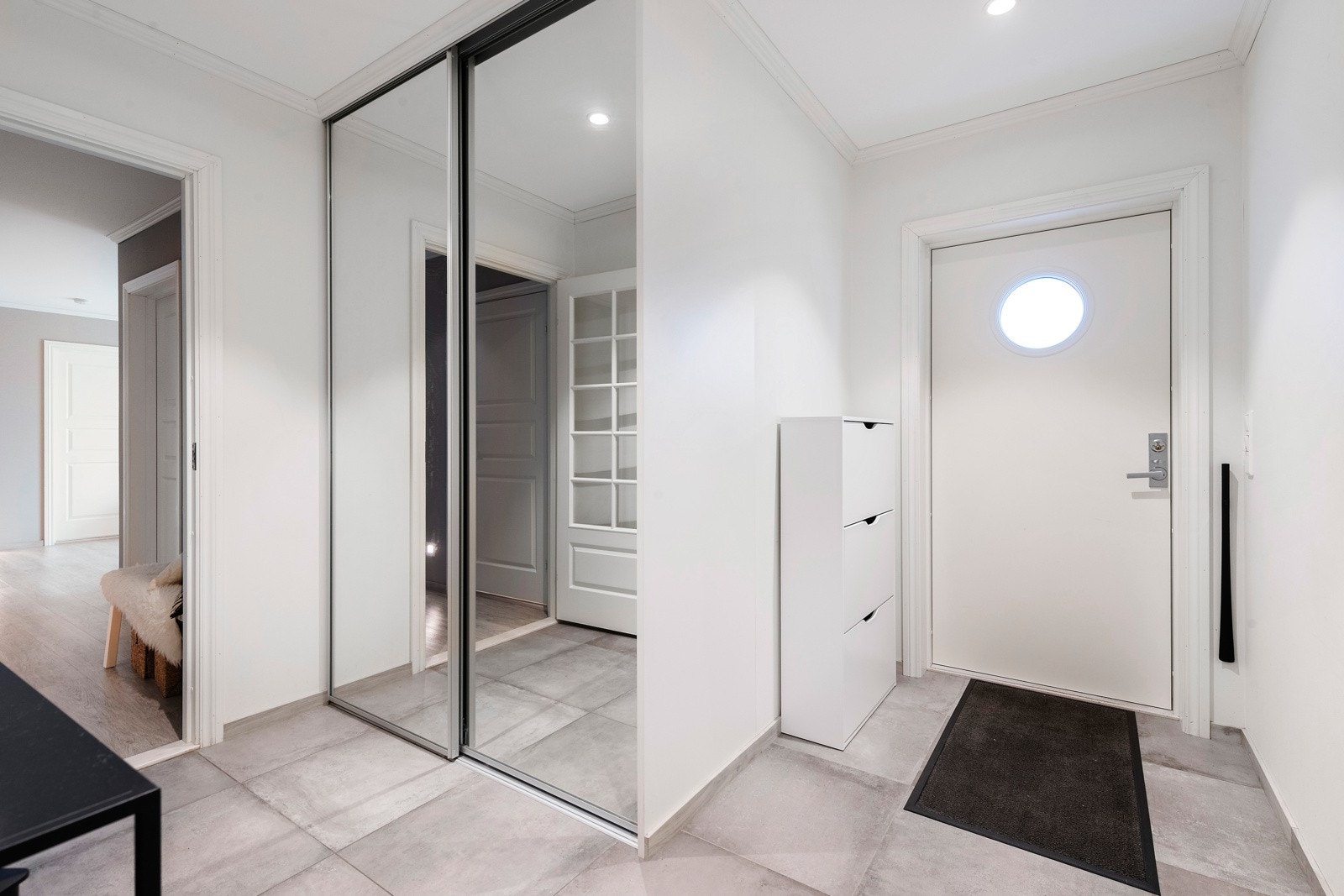 Flislagt entré med skyvedørsgarderobe. Galleribilde