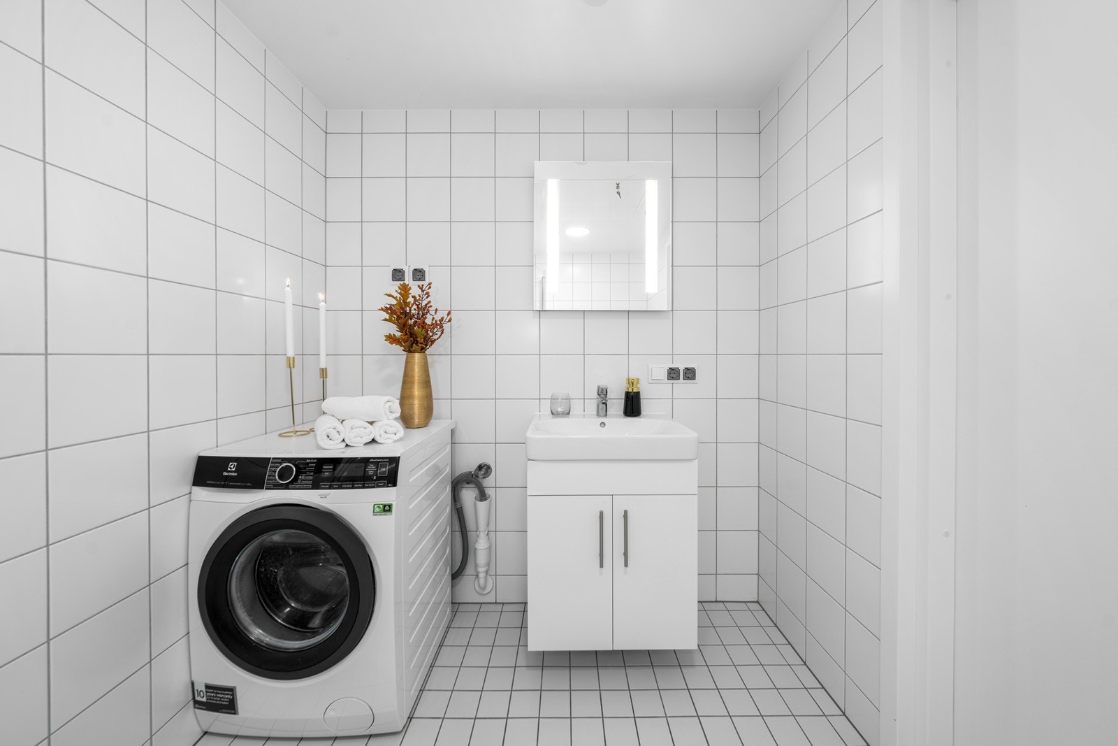 Lyst og moderne baderom med heldekkende servant, 1-greps blandebatteri, underskap, vegghengt speil med LED belysning, vegghengt toalett med innebygd sisterne og opplegg for vaskemaskin! Galleribilde