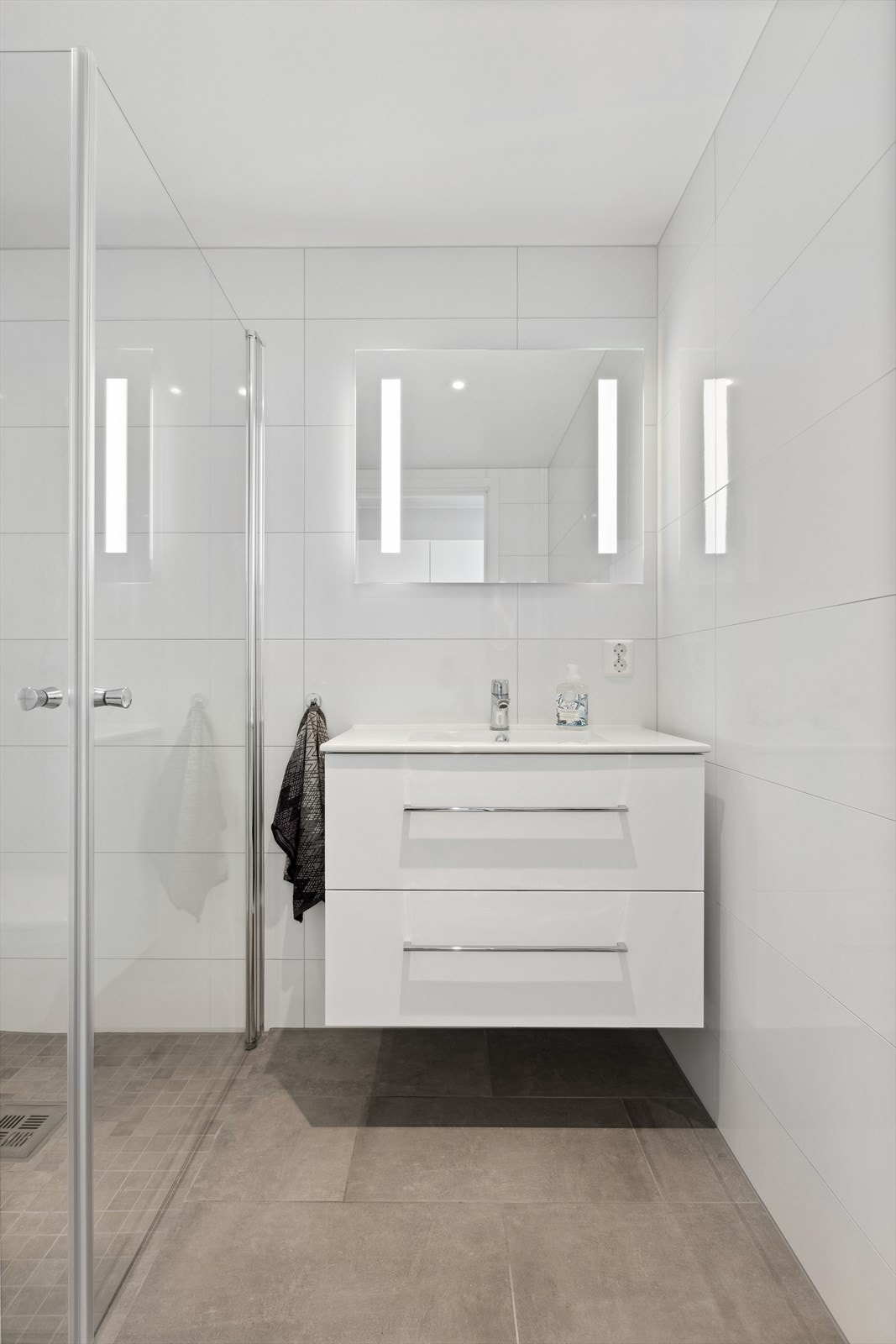 Delikat bad med flislagt gulv med vannbåren gulvvarme og downlights i himlingen. Galleribilde
