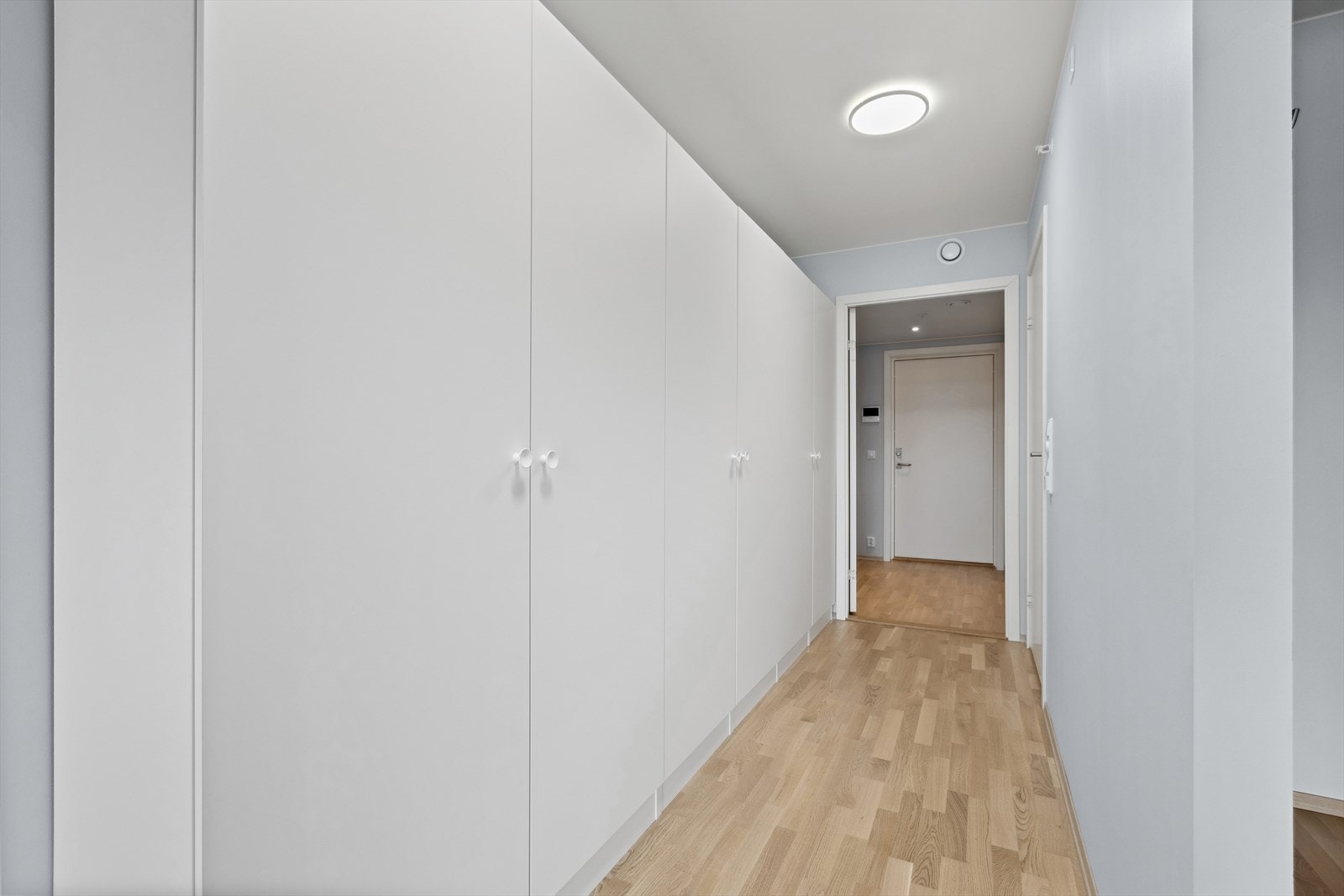 Romslig hall med rikelig garderobeskap på hele langvegg. Galleribilde